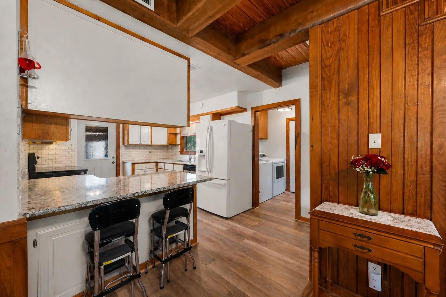 Breakfast bar overlooks the open kitchen and dining areas with rustic wood accents.