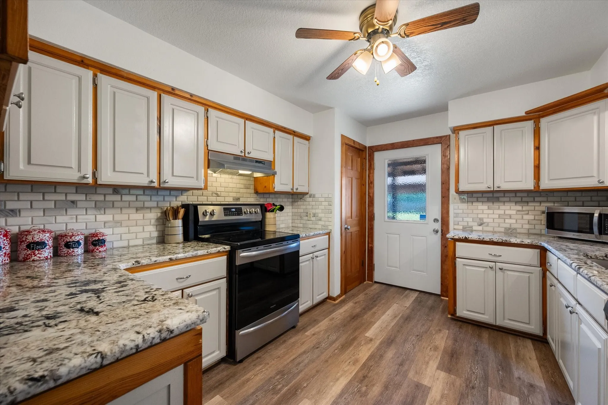 Spacious kitchen featuring granite counters, abundant cabinetry, and modern appliances.