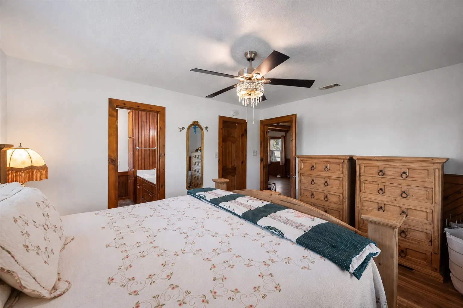 Primary bedroom with generous floor space and warm wood accents.