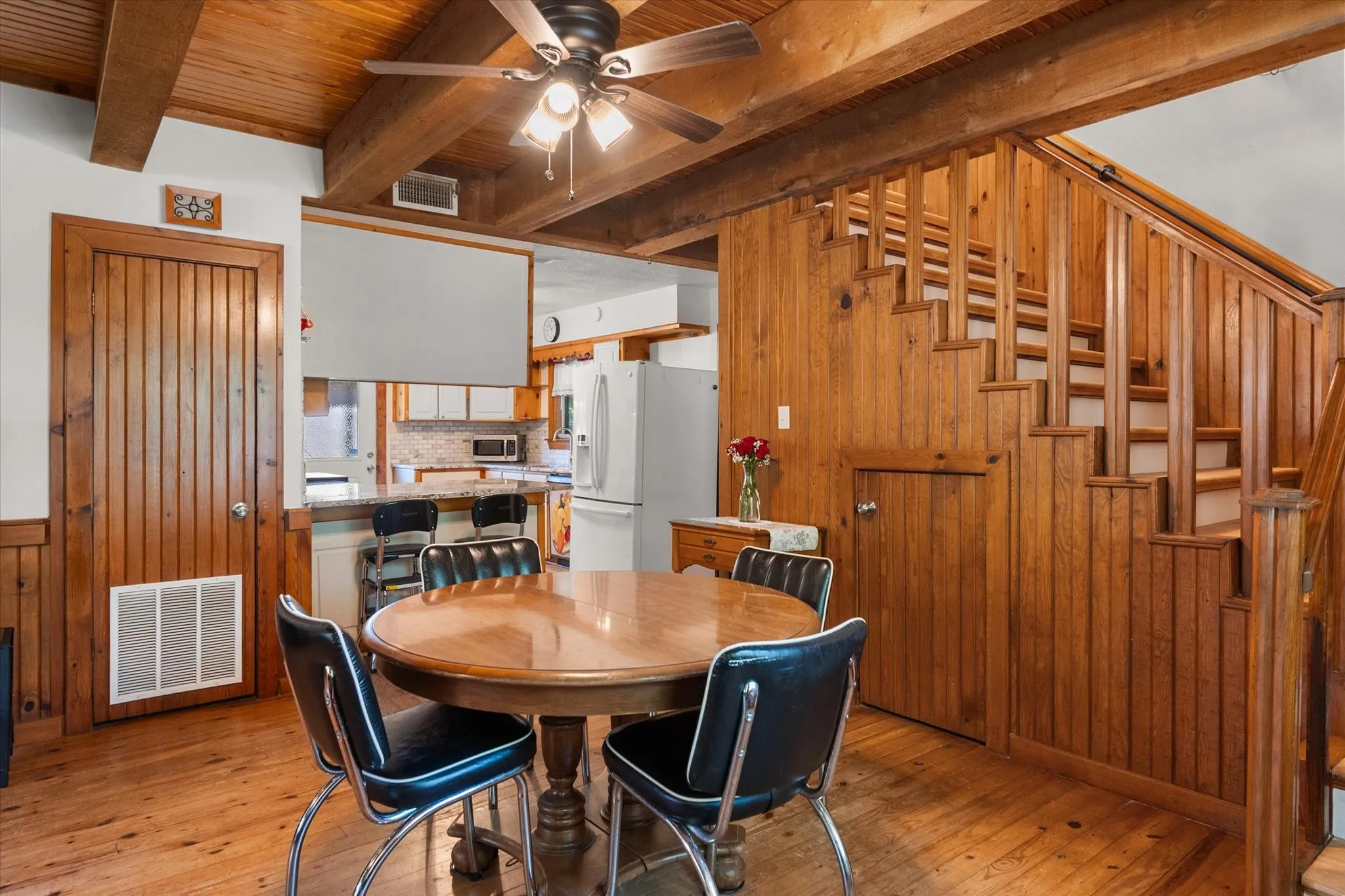 Dining area opens seamlessly to the kitchen beneath beautiful exposed wood beams.