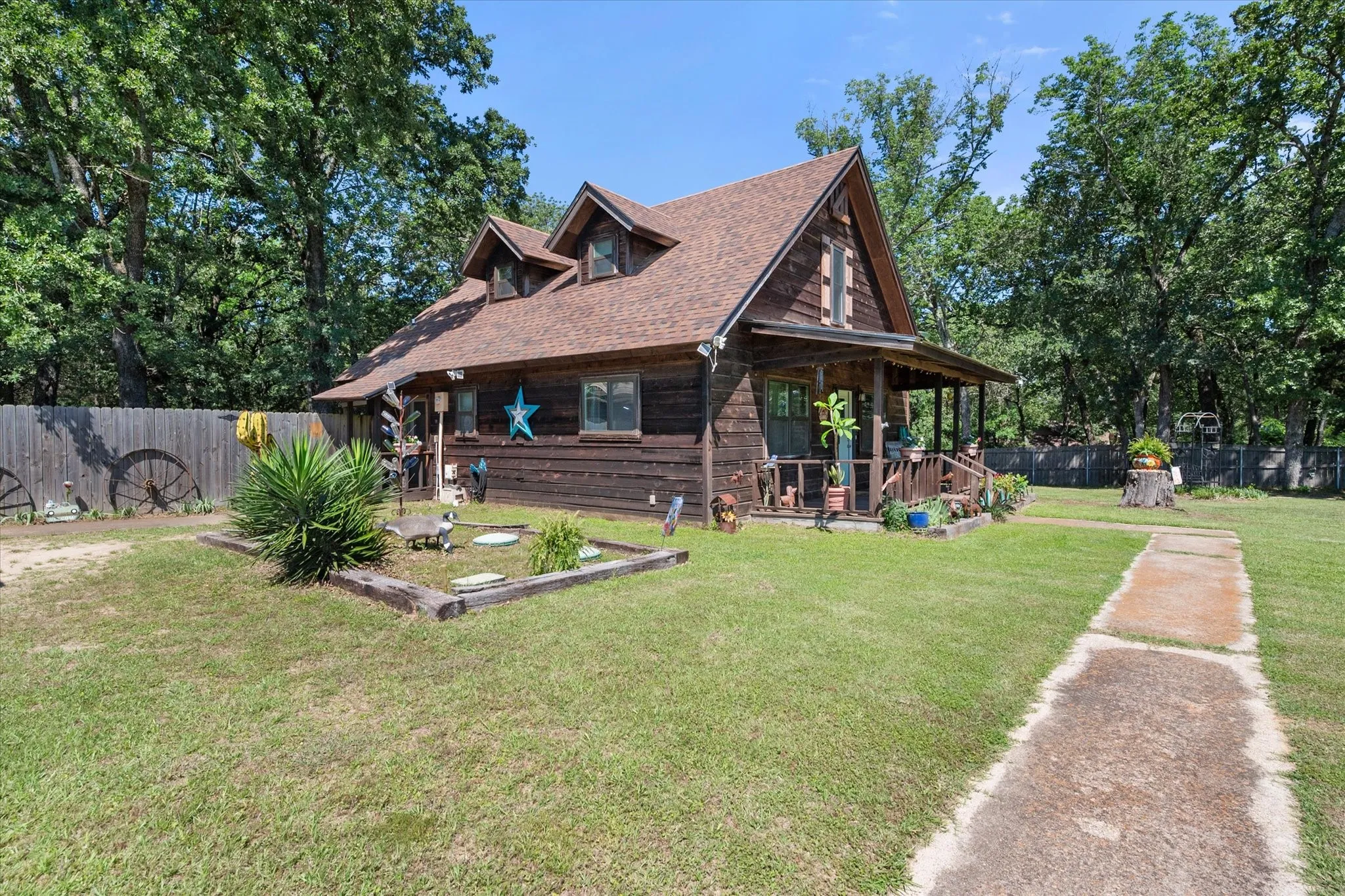 Front exterior highlights mature landscaping and classic cabin architecture.