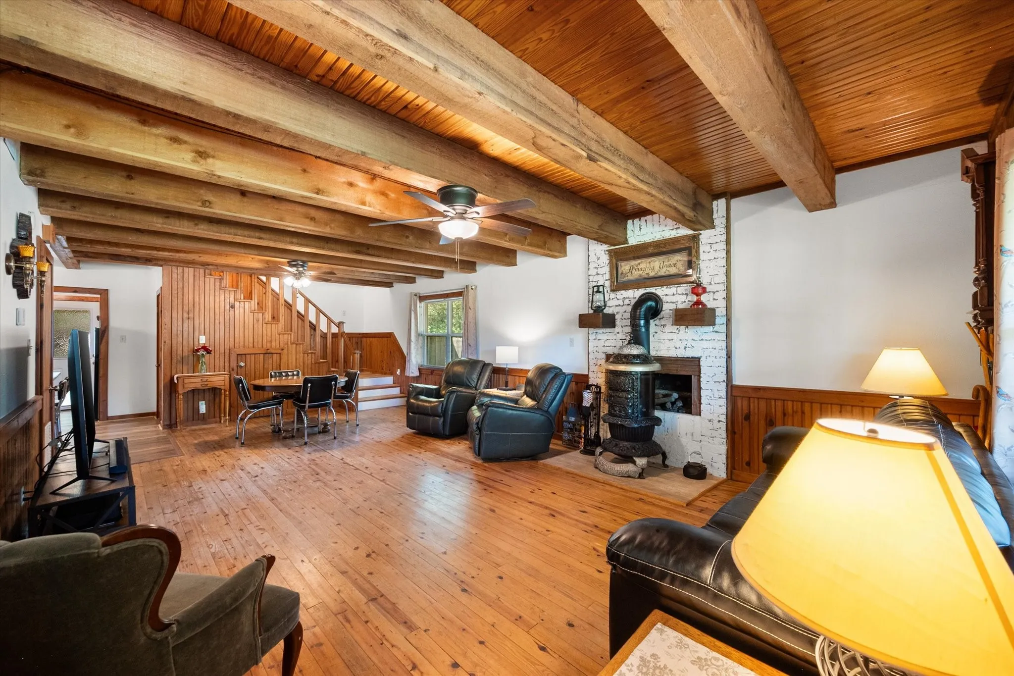 Expansive living room with soaring ceilings, exposed beams, and open flow into dining space.