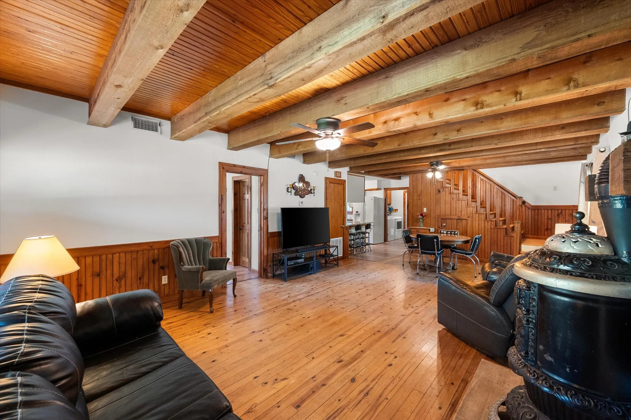 Open-concept living area with rustic cabin charm, natural woodwork, and spacious gathering areas.
