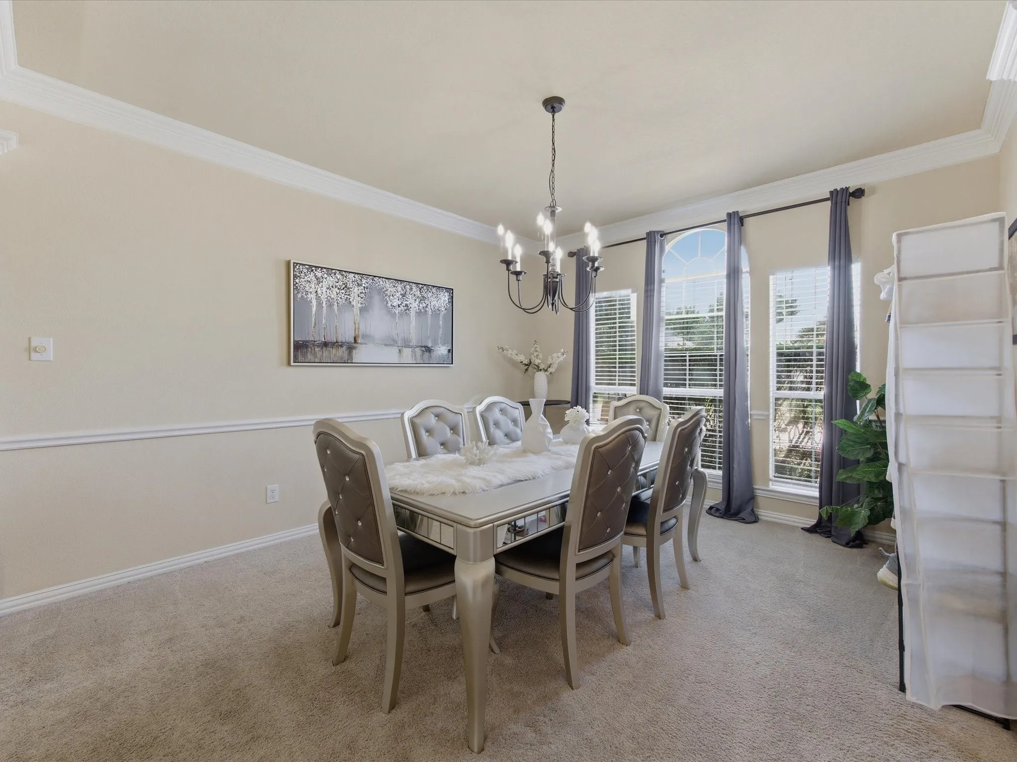 Formal dining area featuring neutral-toned carpeting and walls with a chair rail