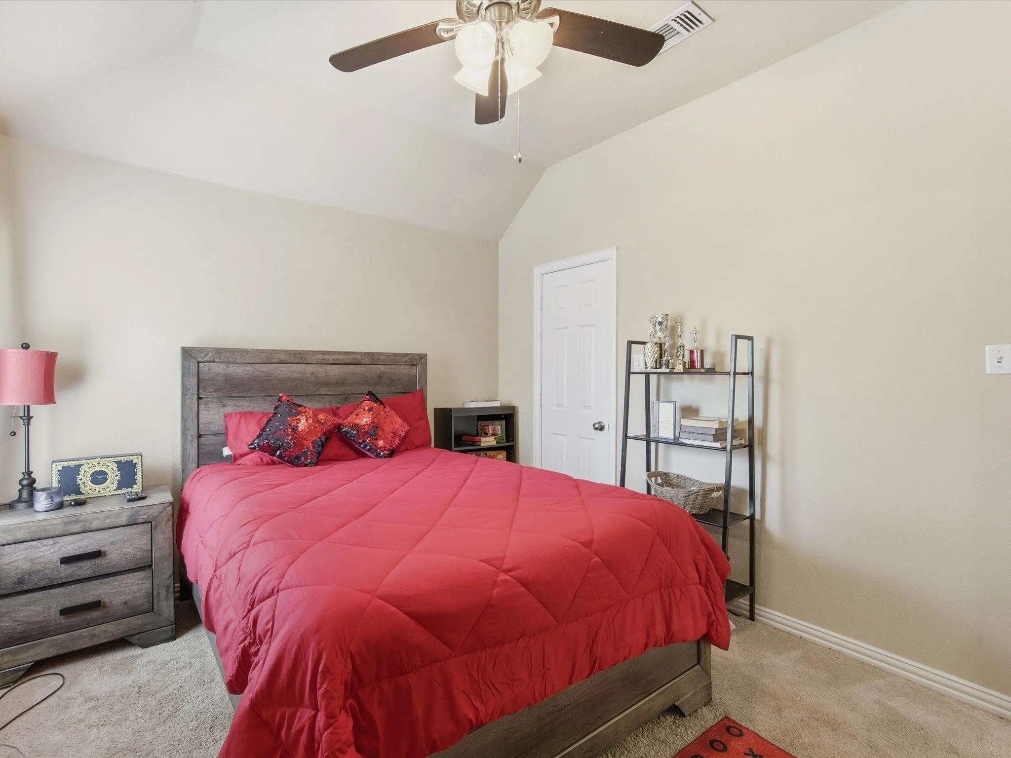 Vaulted ceiling bedroom featuring plush carpeting and a ceiling fan with integrated lighting