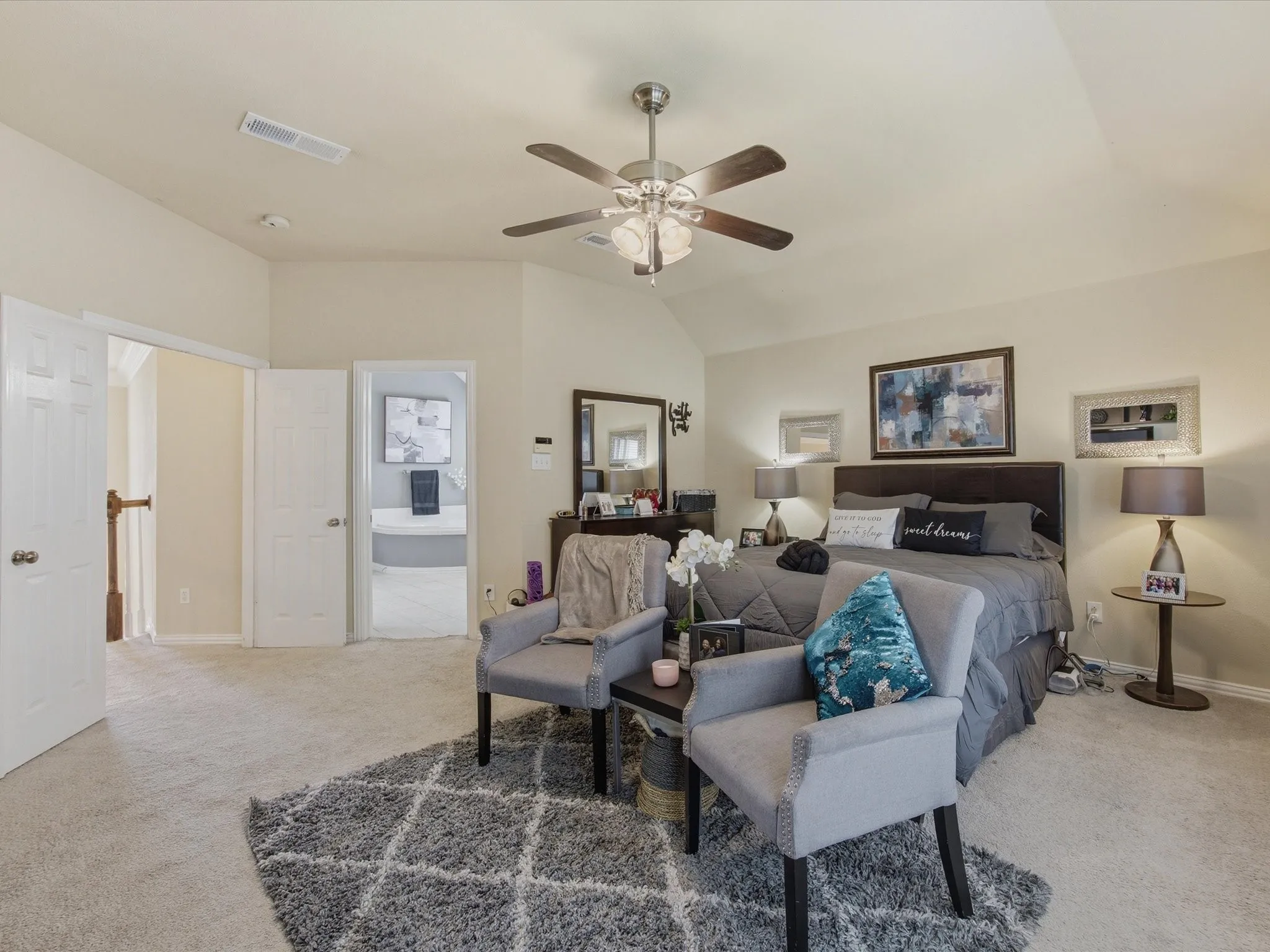 Vaulted ceiling with an attached ceiling fan, neutral carpet flooring, and white paneled doors