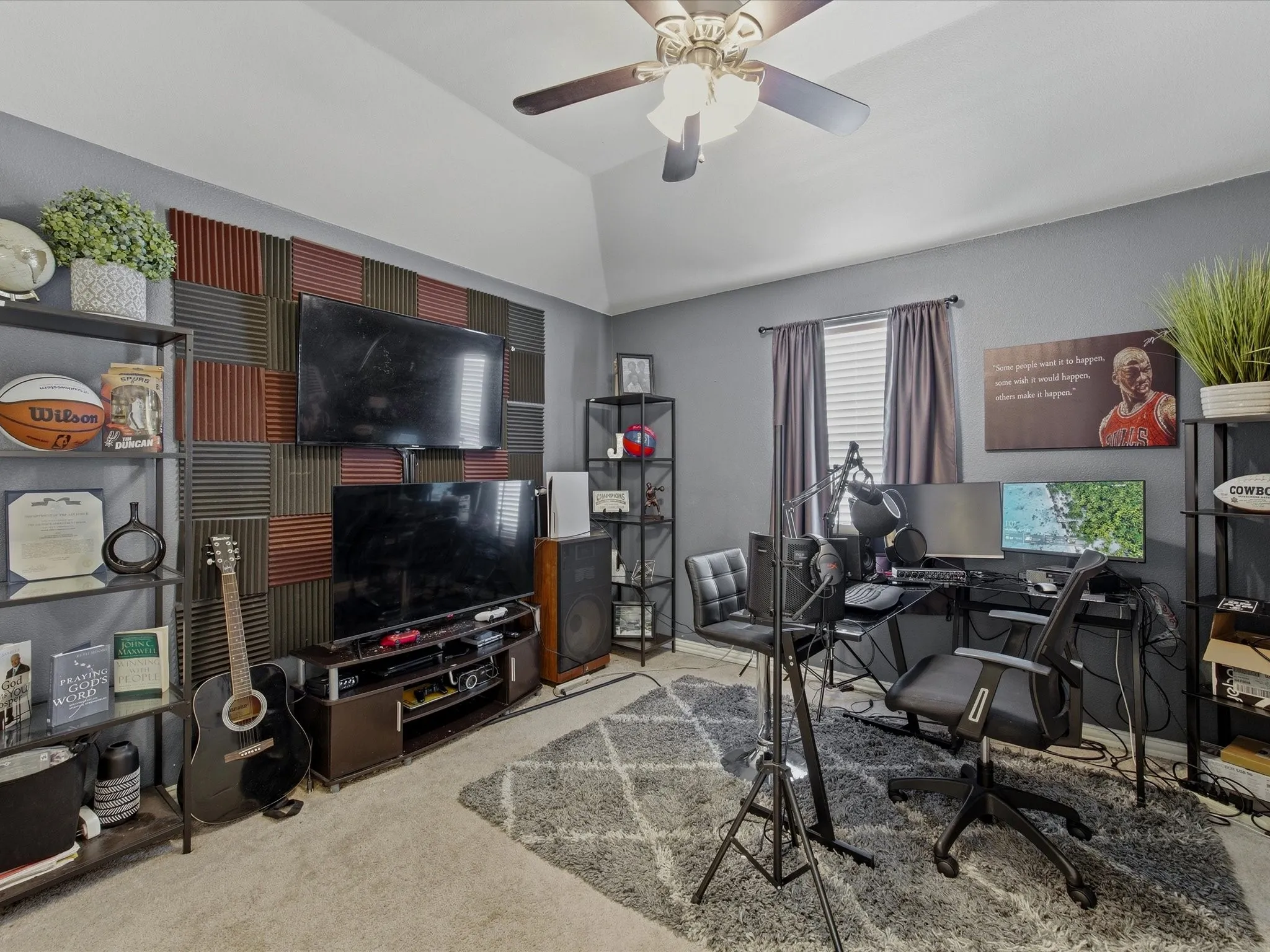 Carpeted room featuring a vaulted ceiling and a ceiling fan with light fixture