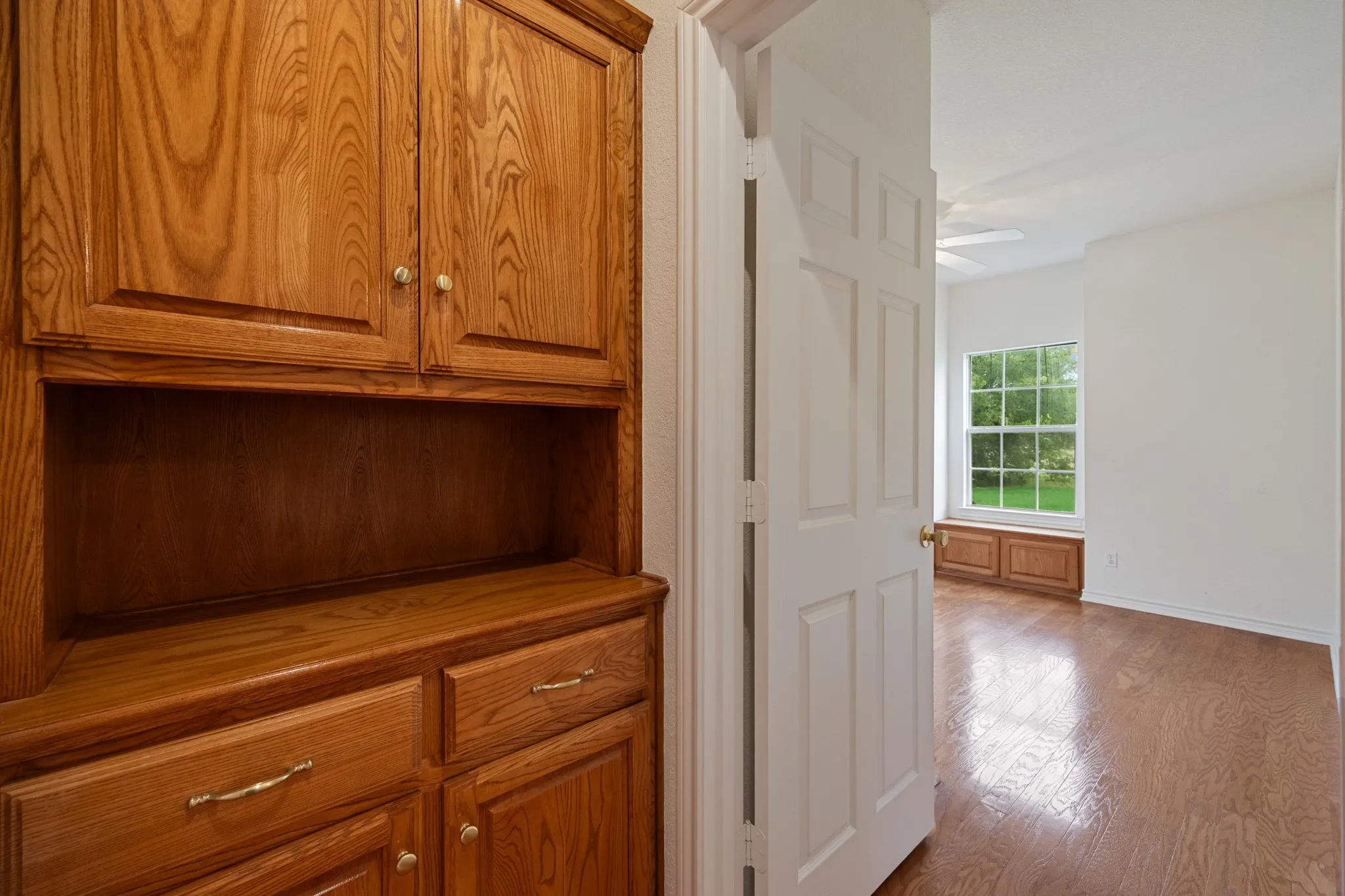 Integrated wood-finish cabinetry with brass hardware