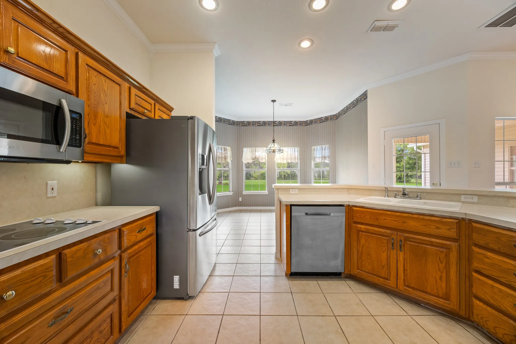Kitchen featuring wood cabinetry, stainless steel appliances, a tile backsplash, and a breakfast​​‌​​​​‌​​‌‌​‌‌​​​‌‌​‌​‌​‌​​​‌​​ bar
