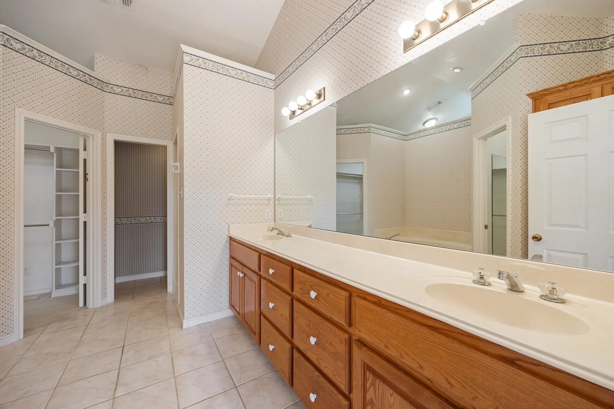 Double vanity with light wood cabinetry and integrated sinks