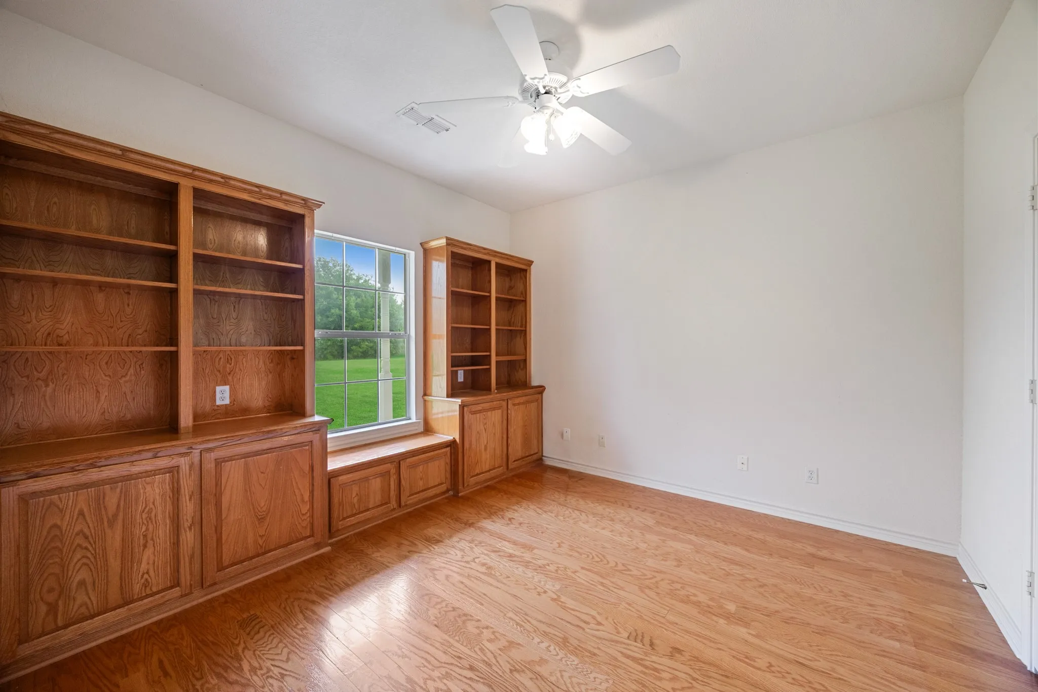 Built-in wooden cabinetry with integrated shelving and a window seat