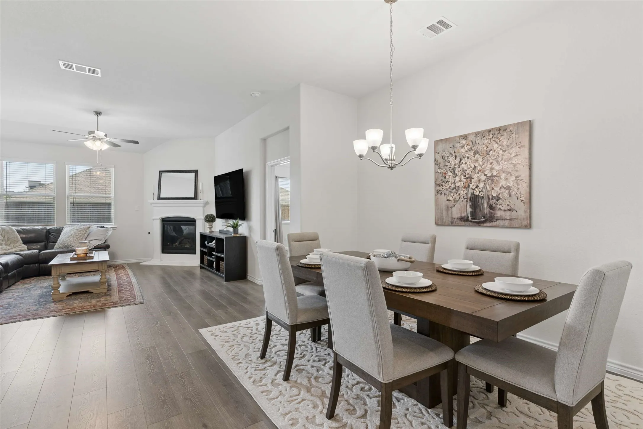 Open-concept living and dining area featuring wood-finish flooring