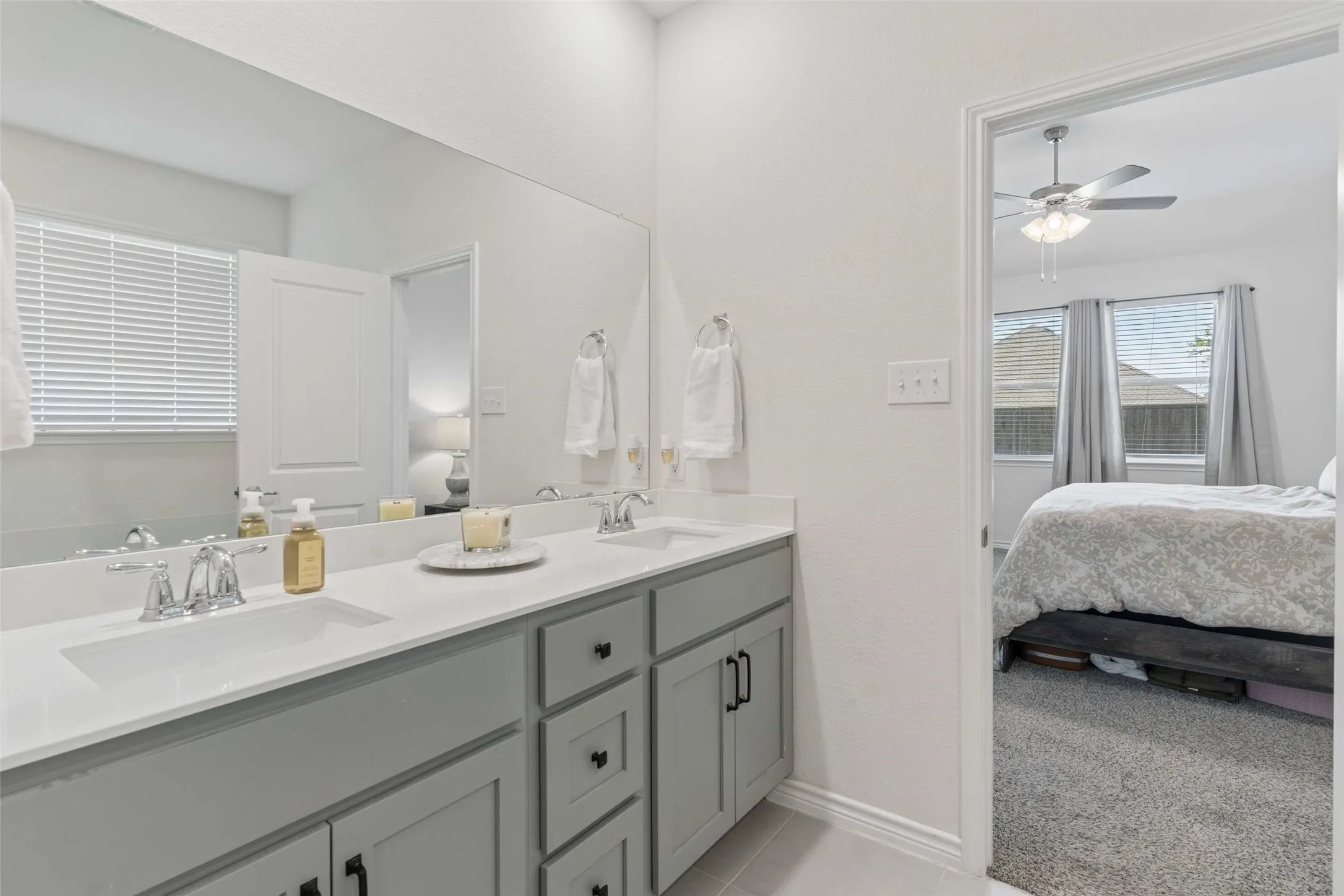 Dual vanity with undermount sinks, chrome fixtures, and light gray cabinetry