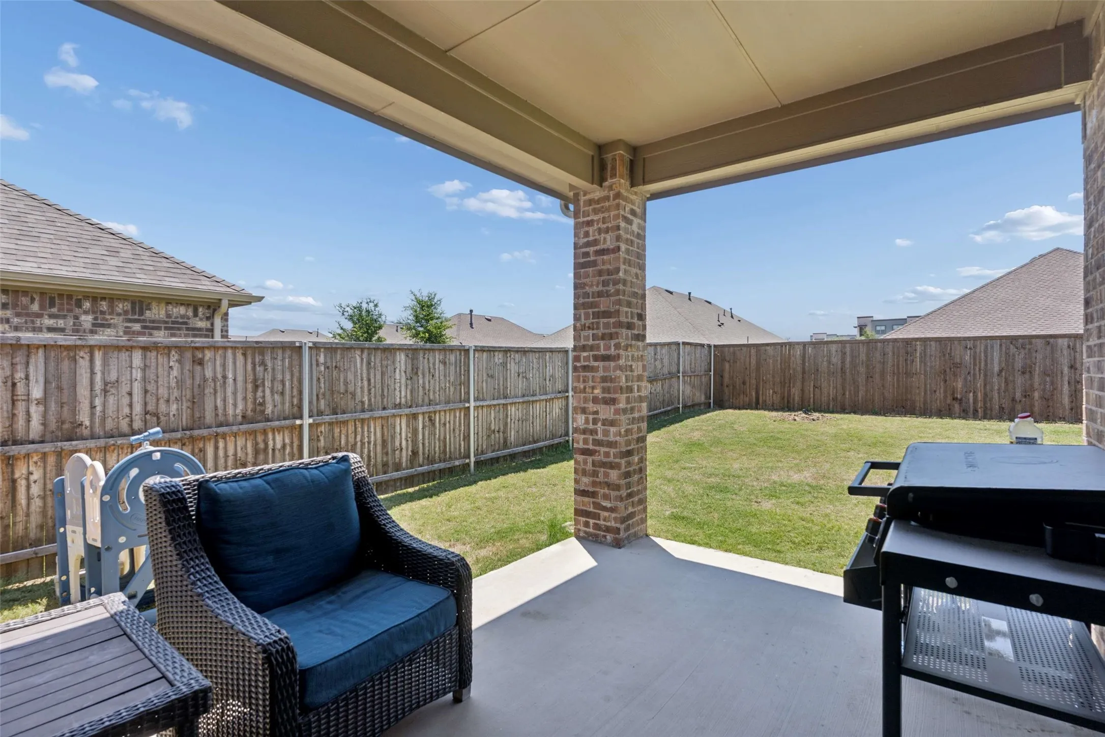 Covered patio with a concrete surface, brick columns, and a flat roof