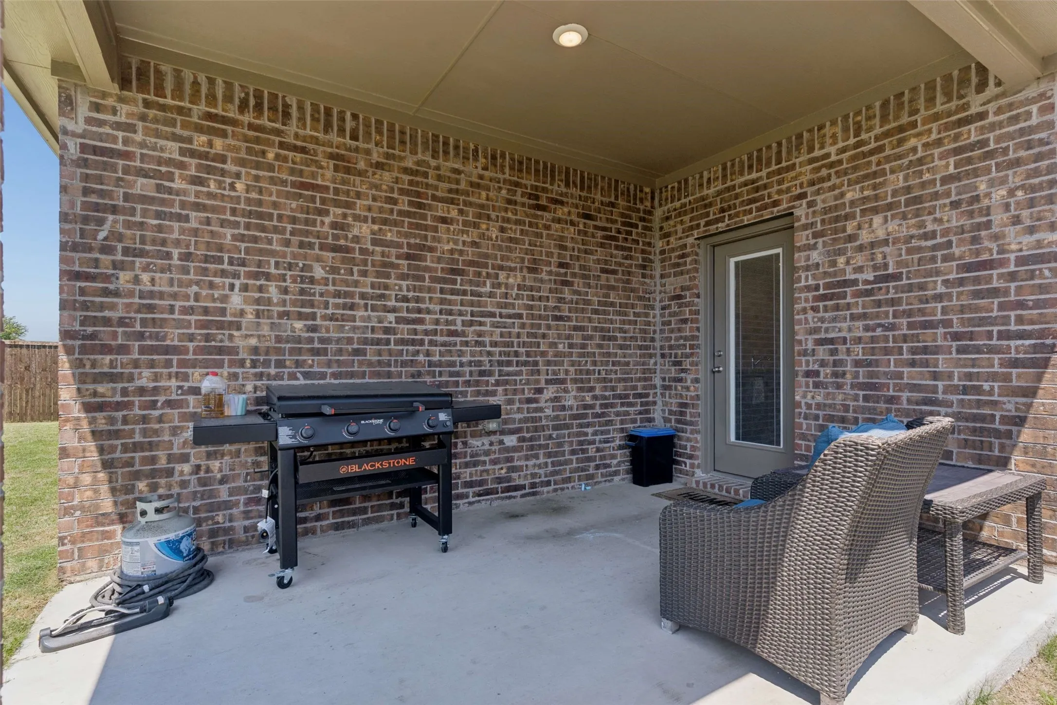 Covered patio featuring a concrete slab, recessed lighting, and a brick exterior wall