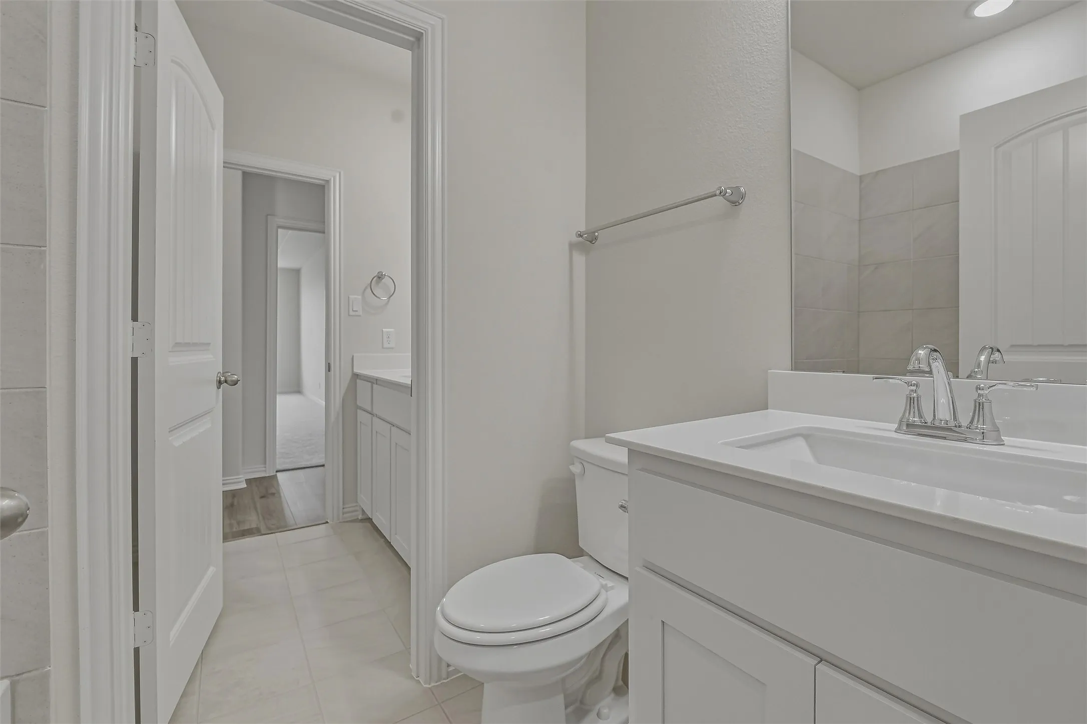 Bathroom vanity with an integrated sink, polished chrome faucet, and expansive wall mirror
