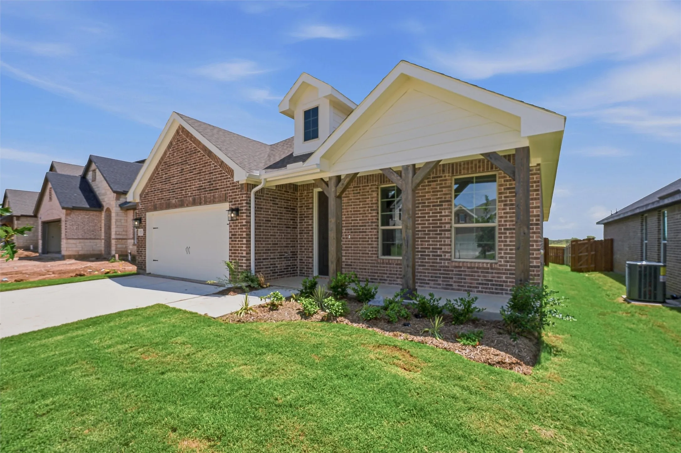 Brick exterior featuring a covered front entry with substantial wood posts