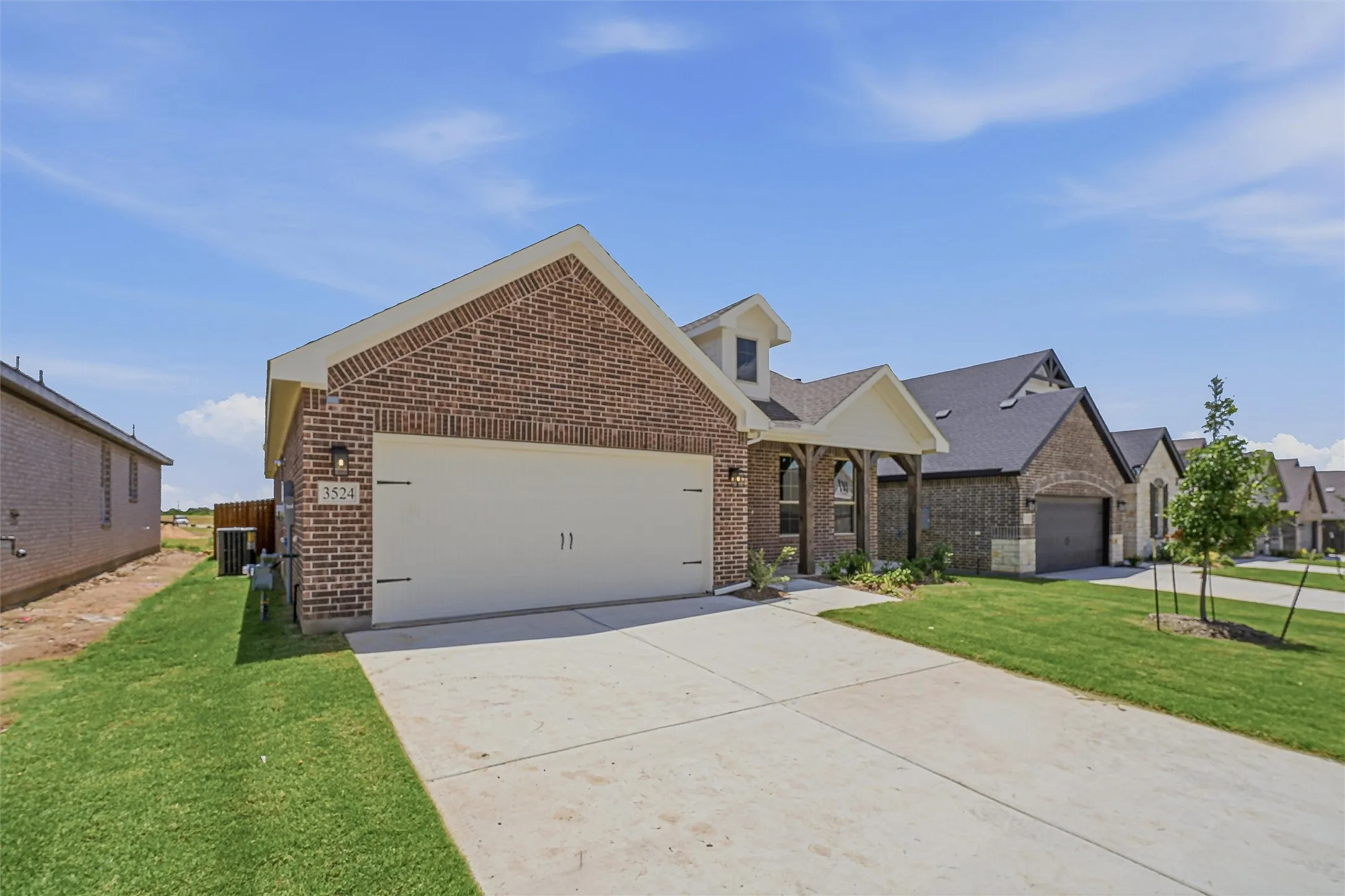 Brick exterior residence featuring an attached two-car garage with a concrete driveway