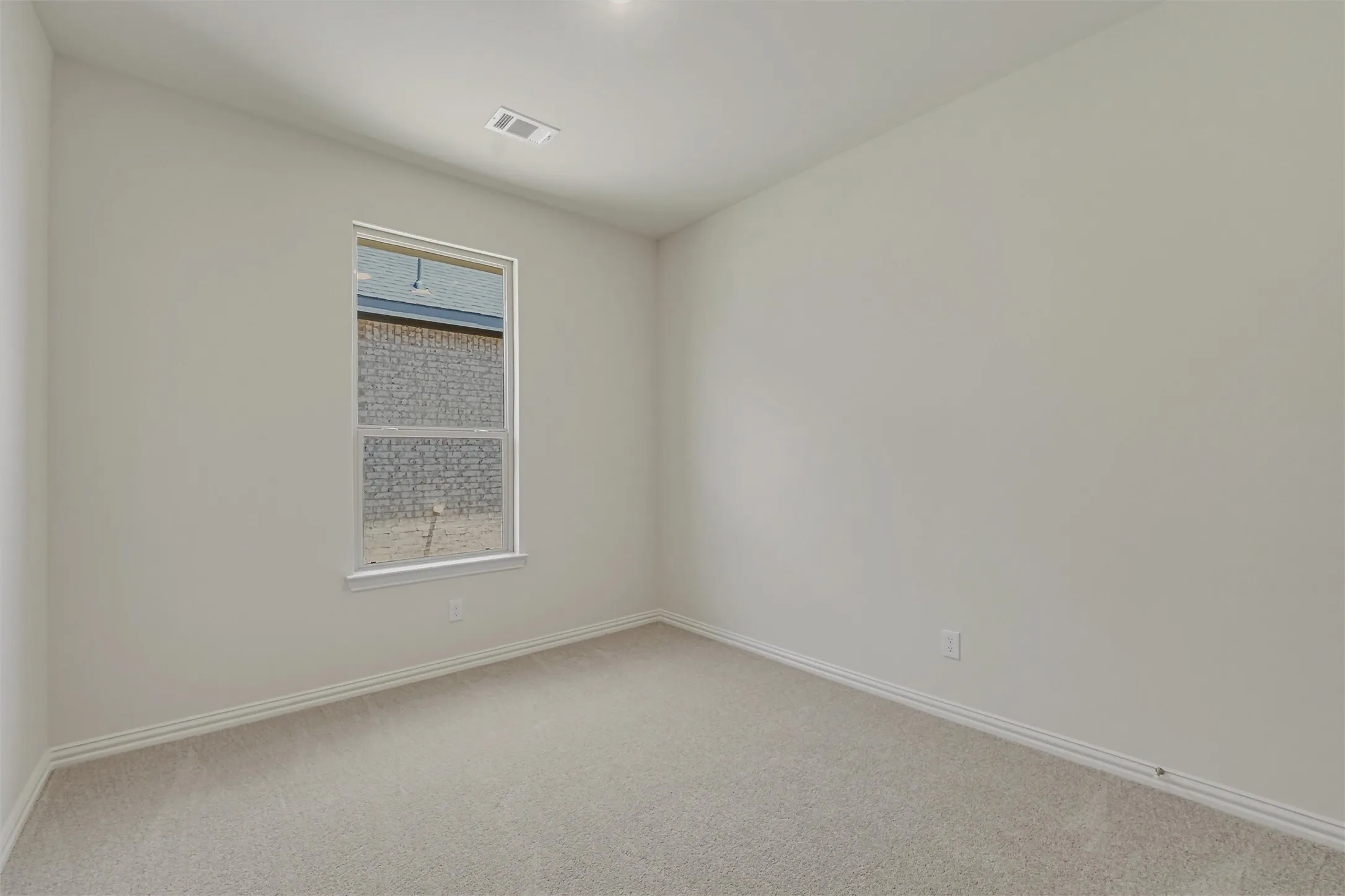 Neutral-toned room featuring a single window and recessed lighting