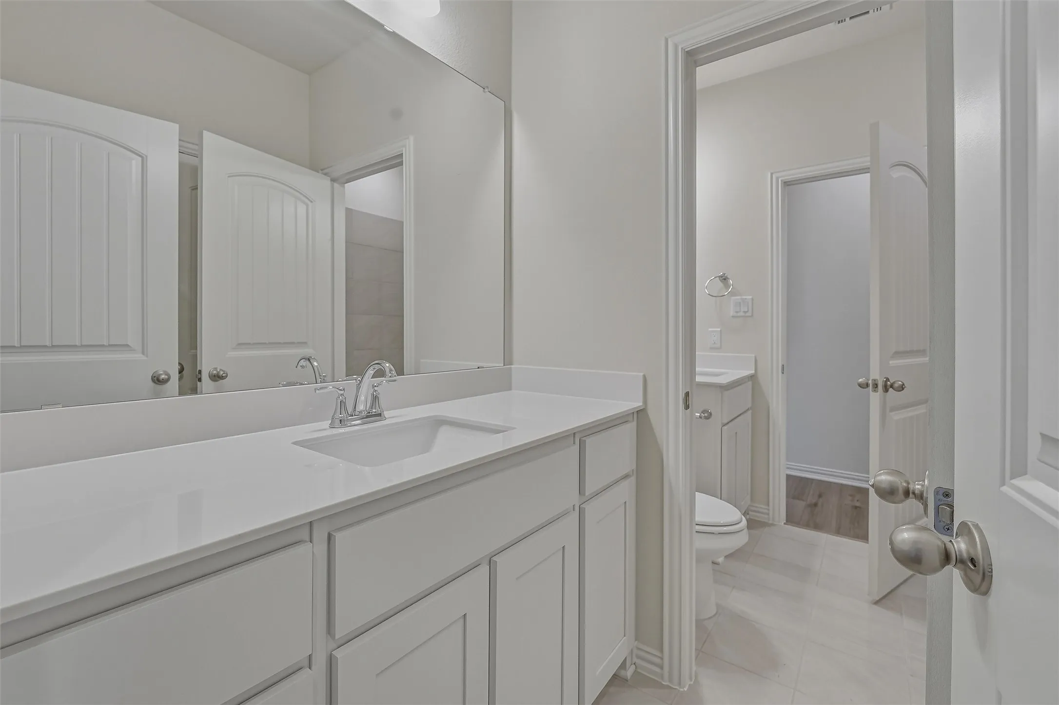 Dual vanity featuring a white countertop with an integrated sink and chrome faucet