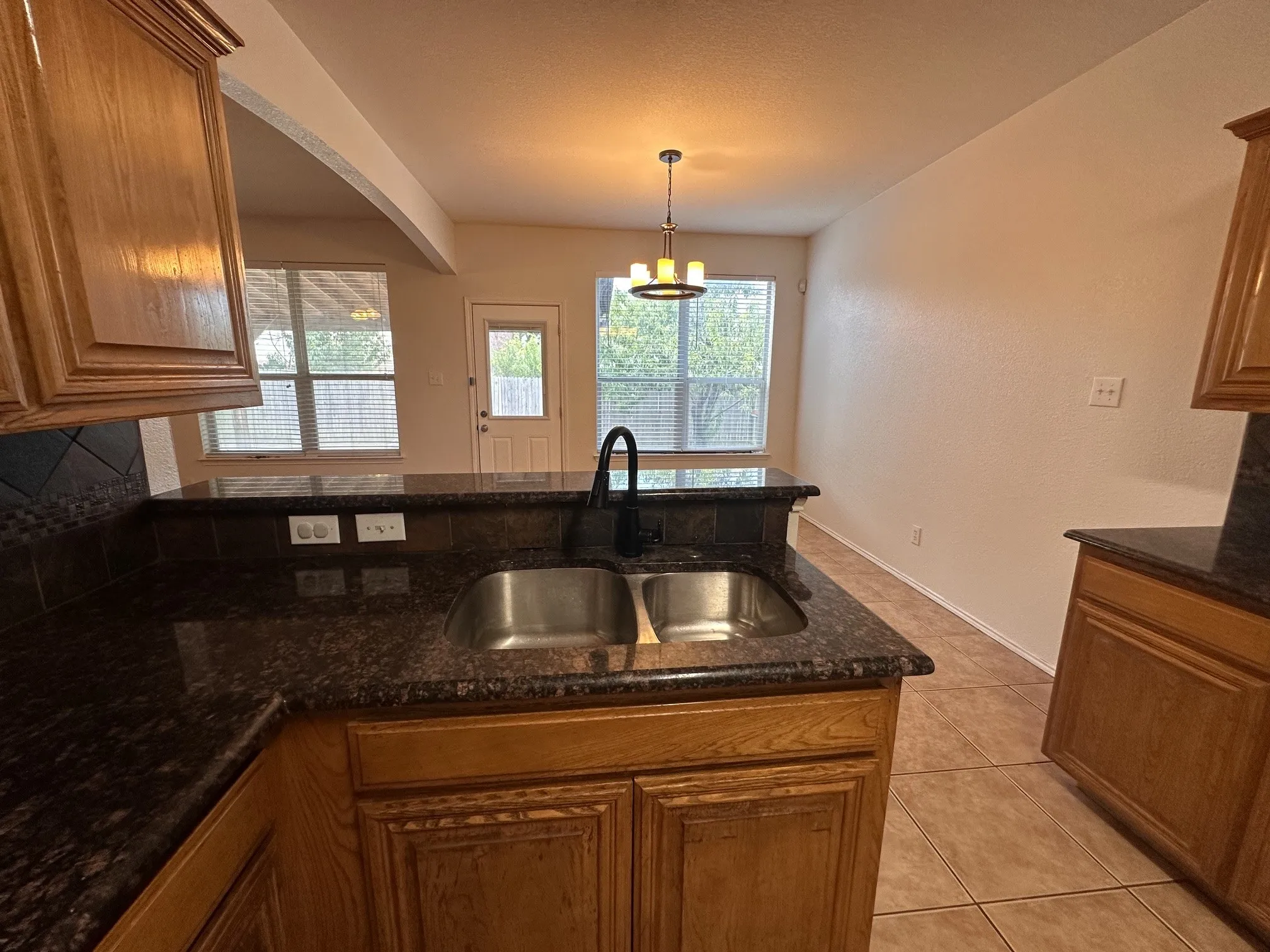 Kitchen featuring a dual basin sink, black fixture, and granite-look countertops