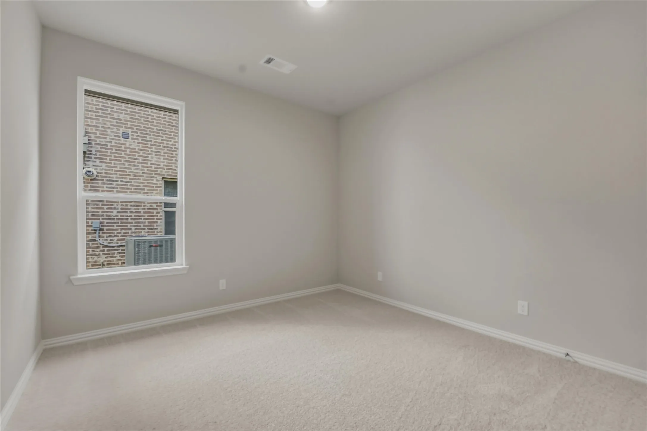 Carpeted room with a double-hung window, light gray wall paint, white baseboards, and a ceiling light fixture