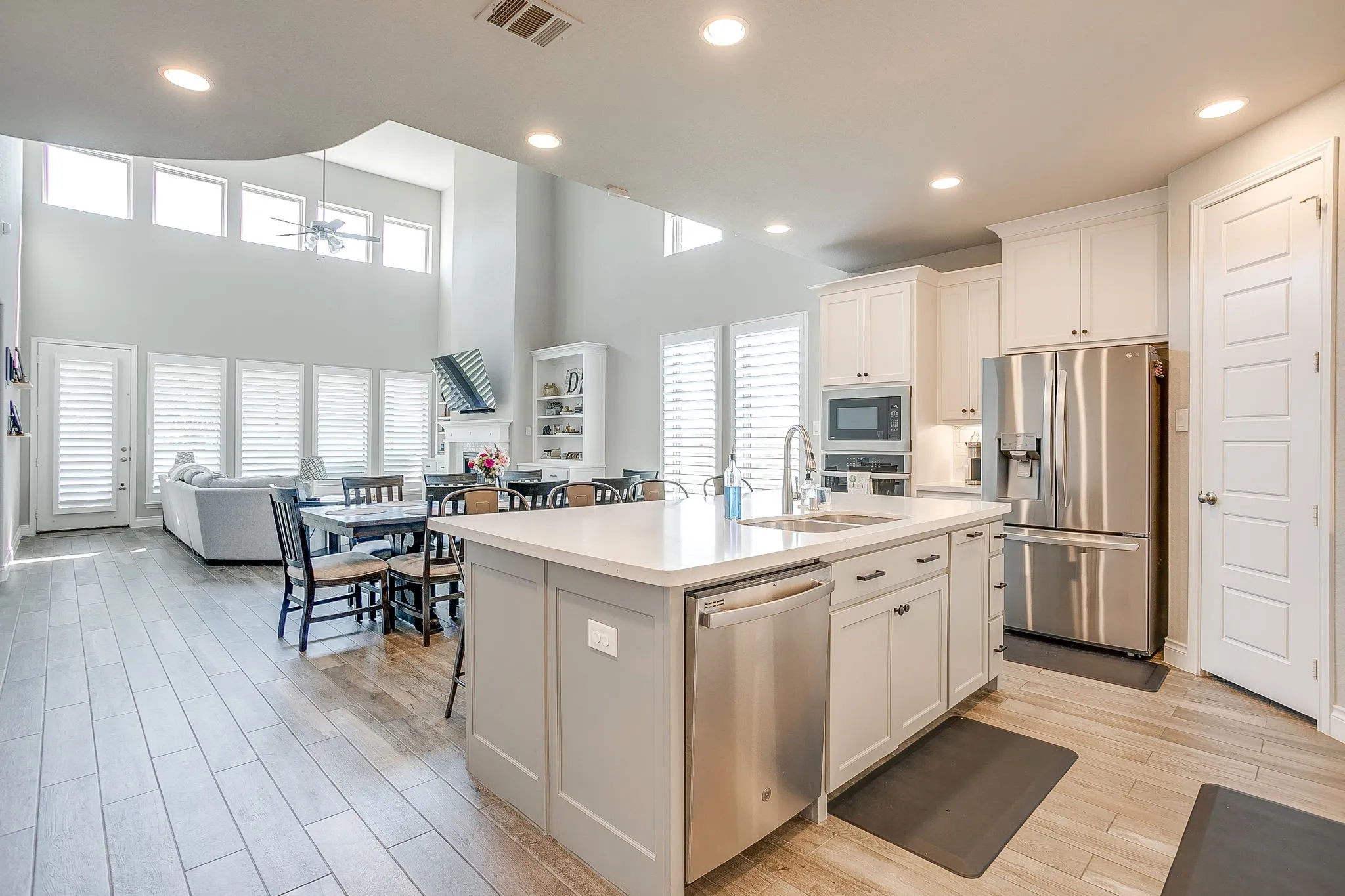 The heart of the home features a bright open-concept design with soaring ceilings, abundant natural light, and a spacious kitchen perfect for everyday living and entertaining.
