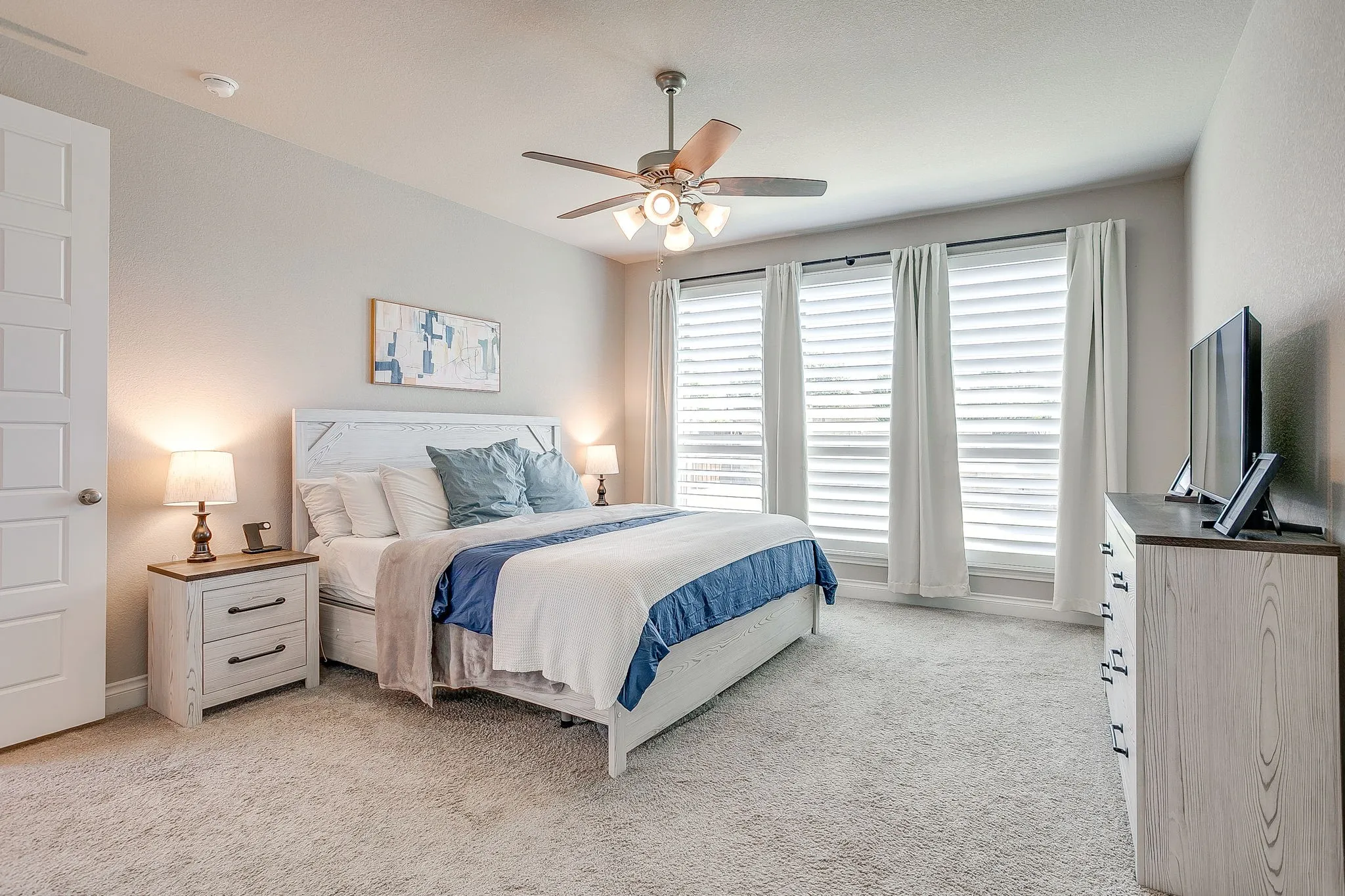 On the first floor, spacious primary suite retreat featuring an expansive bedroom, large windows, a spa-like bath, and generous his-and-hers closets!
