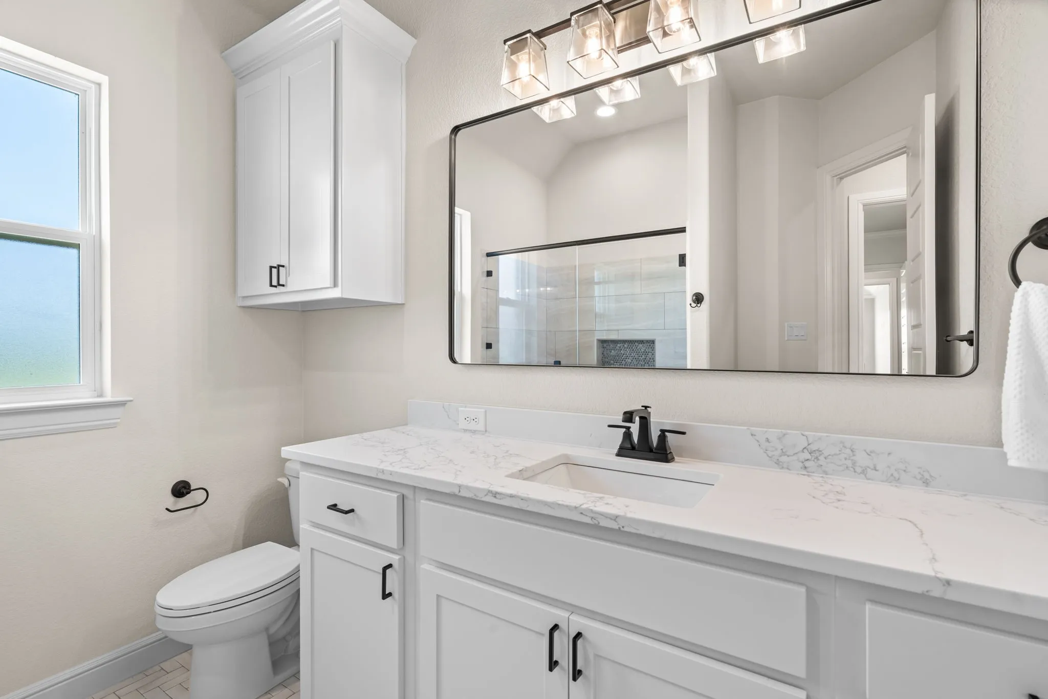 Guest Bathroom with Walk-In Shower, Storage Cabinetry & Decorative Hardware and Tile.