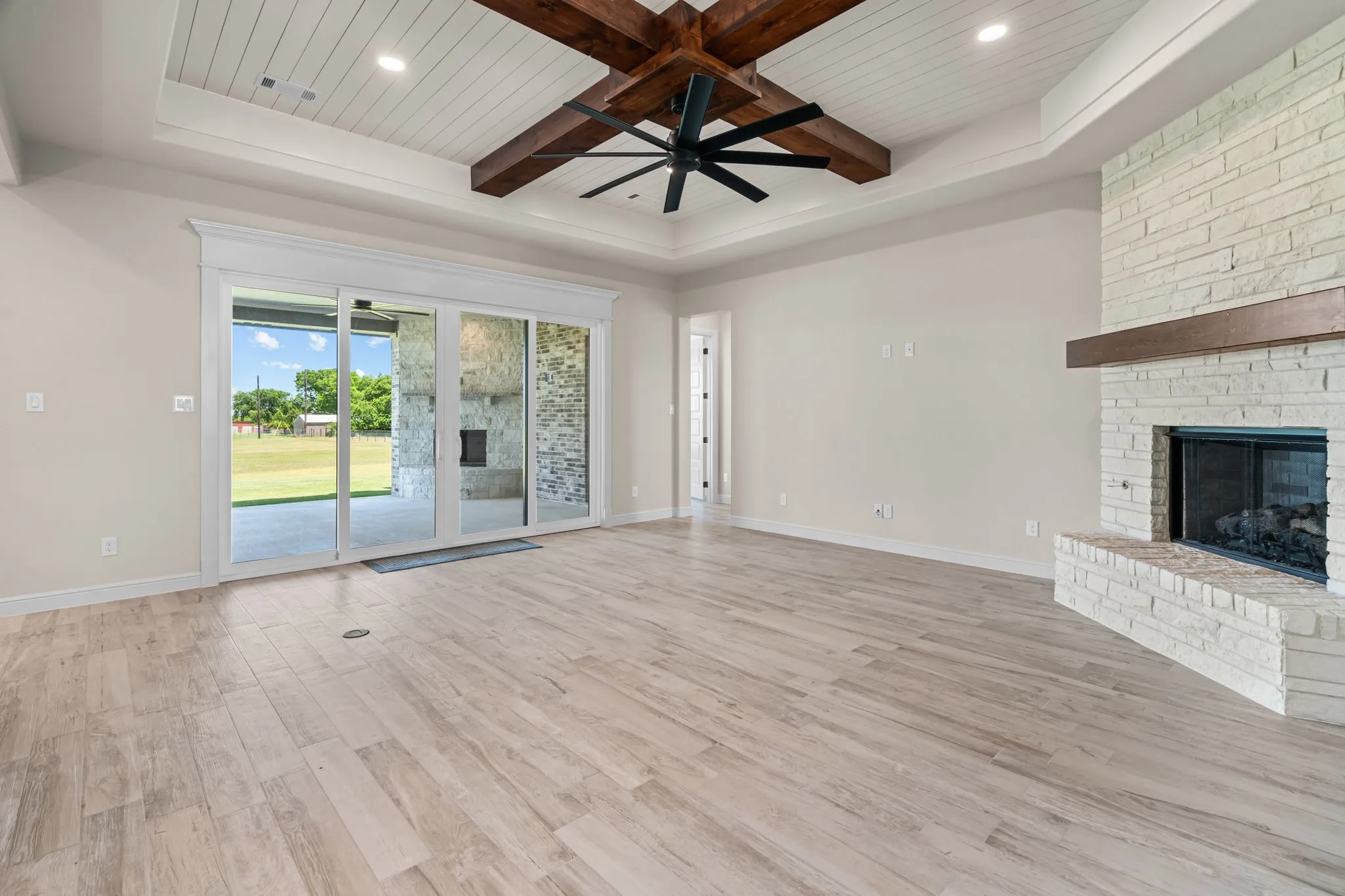 Spacious Living Room offers a Gas Fireplace, Wood Beamed Ceiling & Great Covered Patio Access