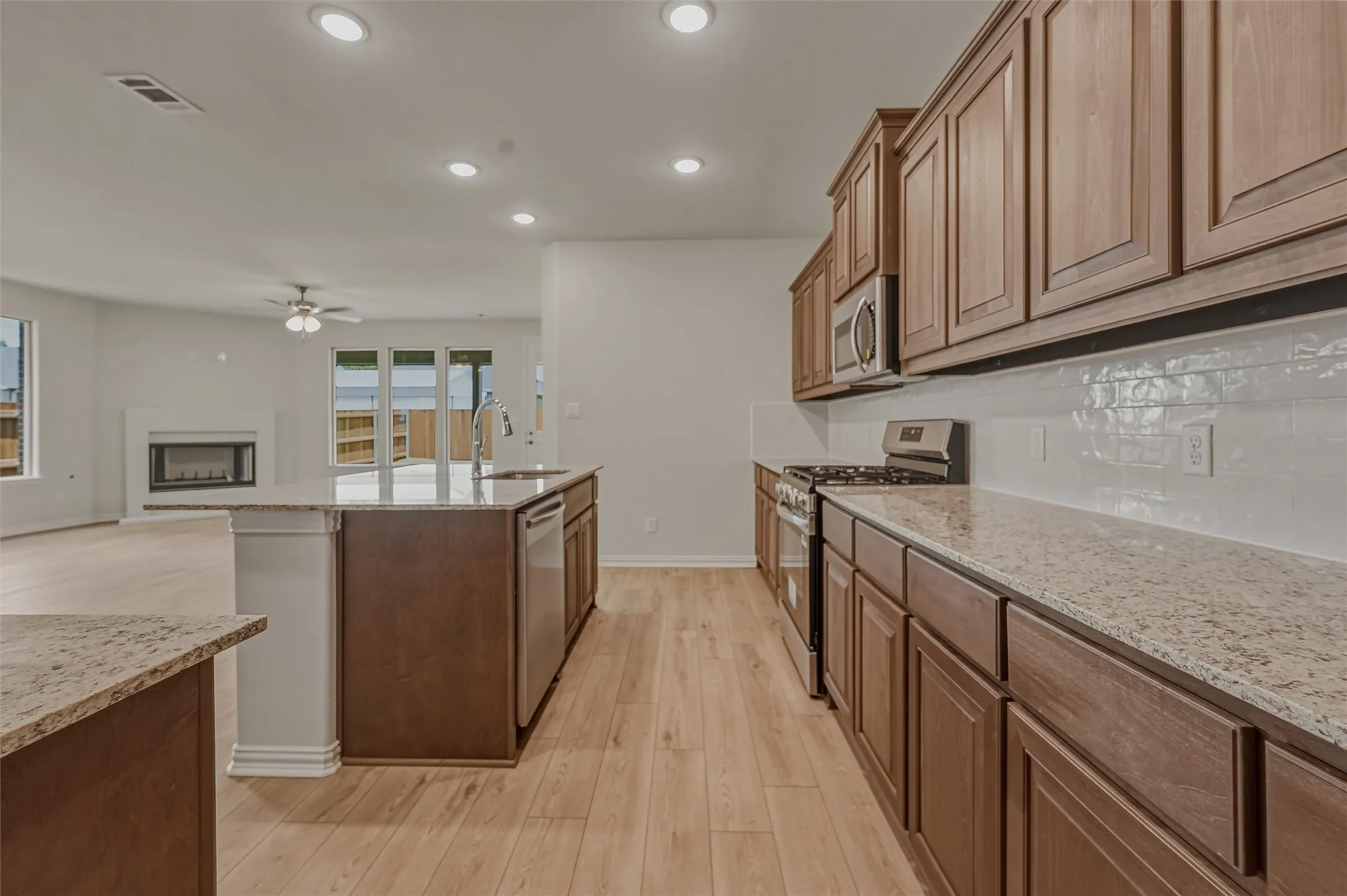 Kitchen featuring wood-finish flooring, recessed lighting, and granite countertops