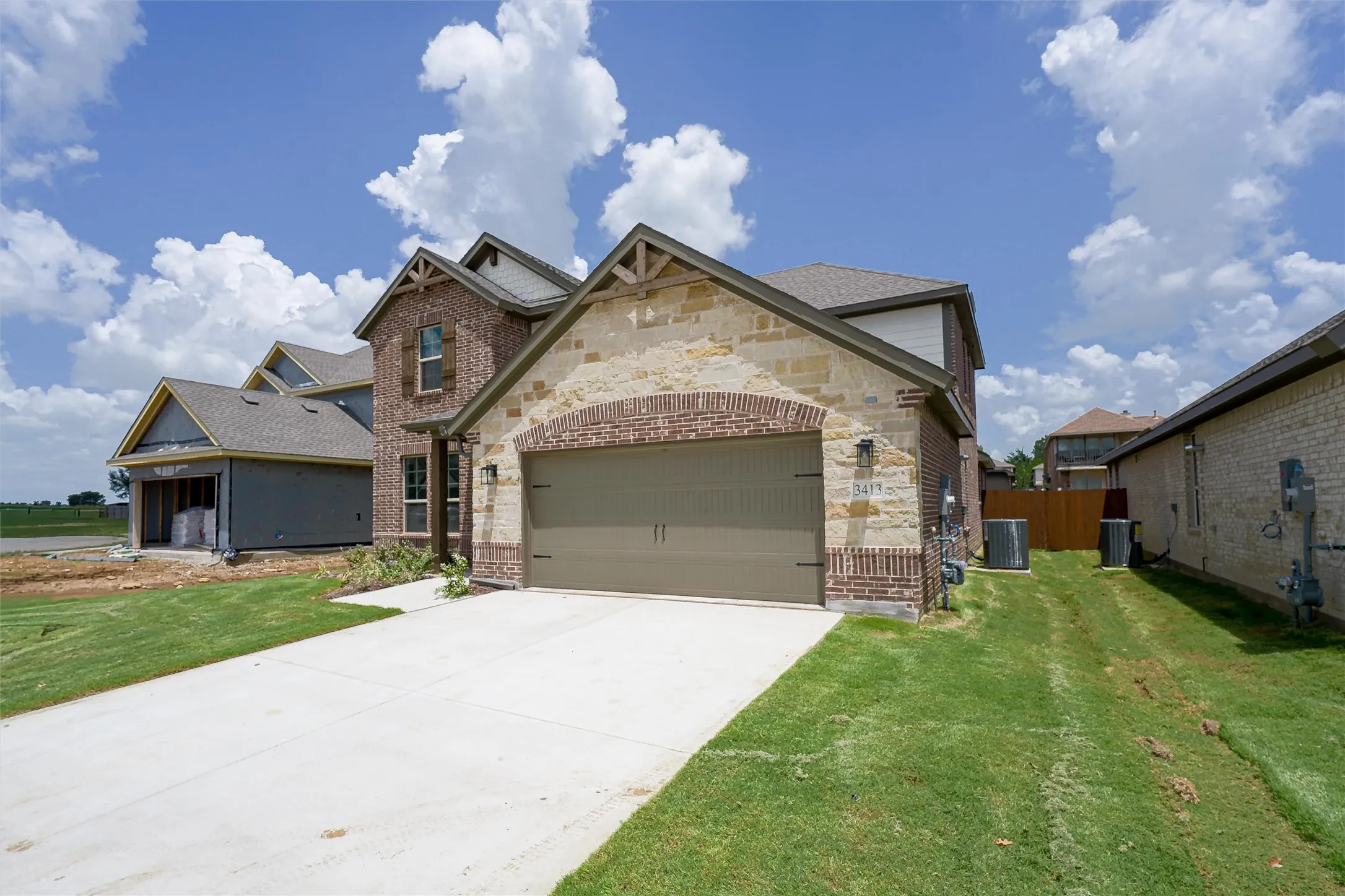 Two-story residence featuring a combination of brick and stone facade