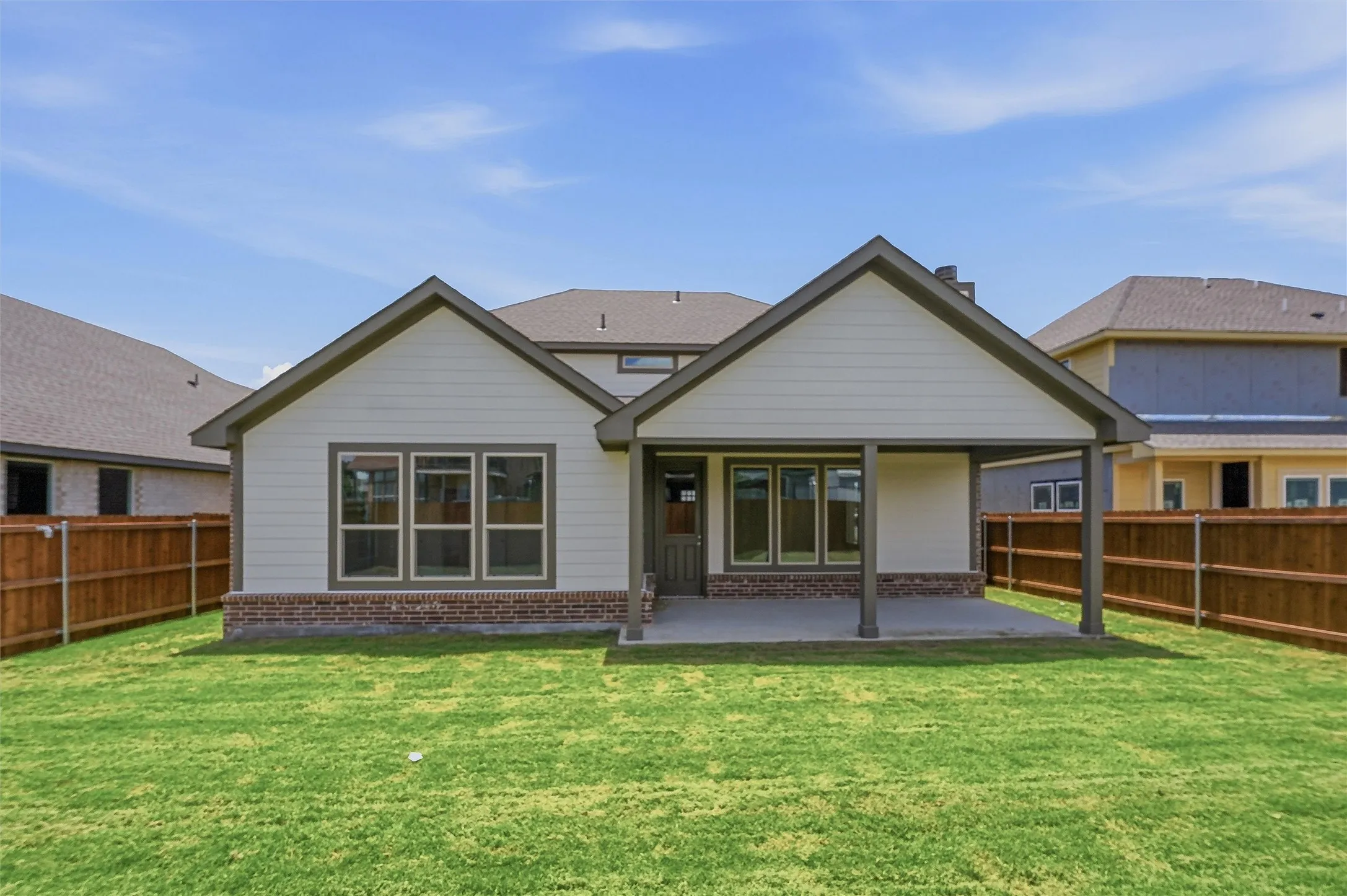 Rear exterior featuring a covered patio, a fenced backyard, and a composition shingle roof