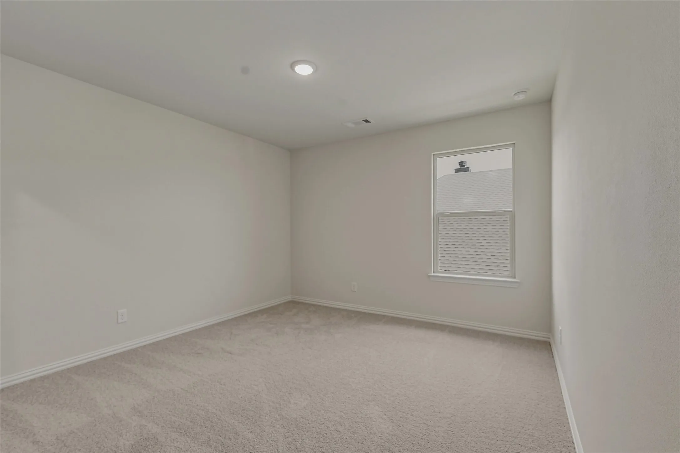 Room featuring neutral wall finishes and light-toned carpet flooring