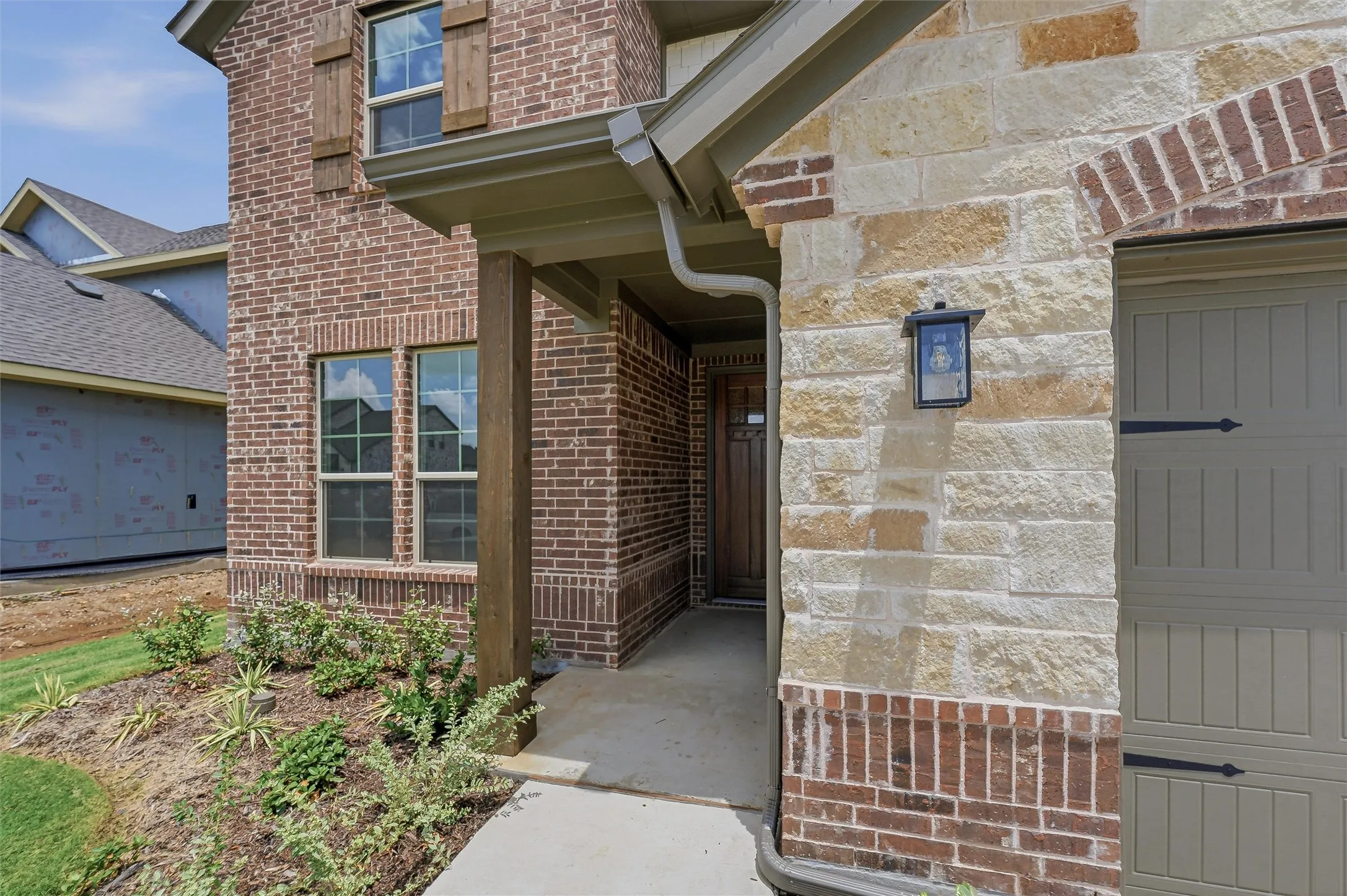 Brick and stone facade featuring a covered entry