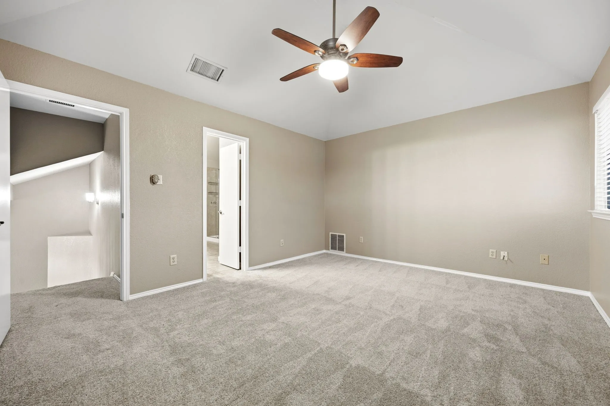 The primary bedroom at 2060 Arbor Creek Drive #B, set apart in the split bedroom floor plan that's popular with Carrollton, TX buyers.
