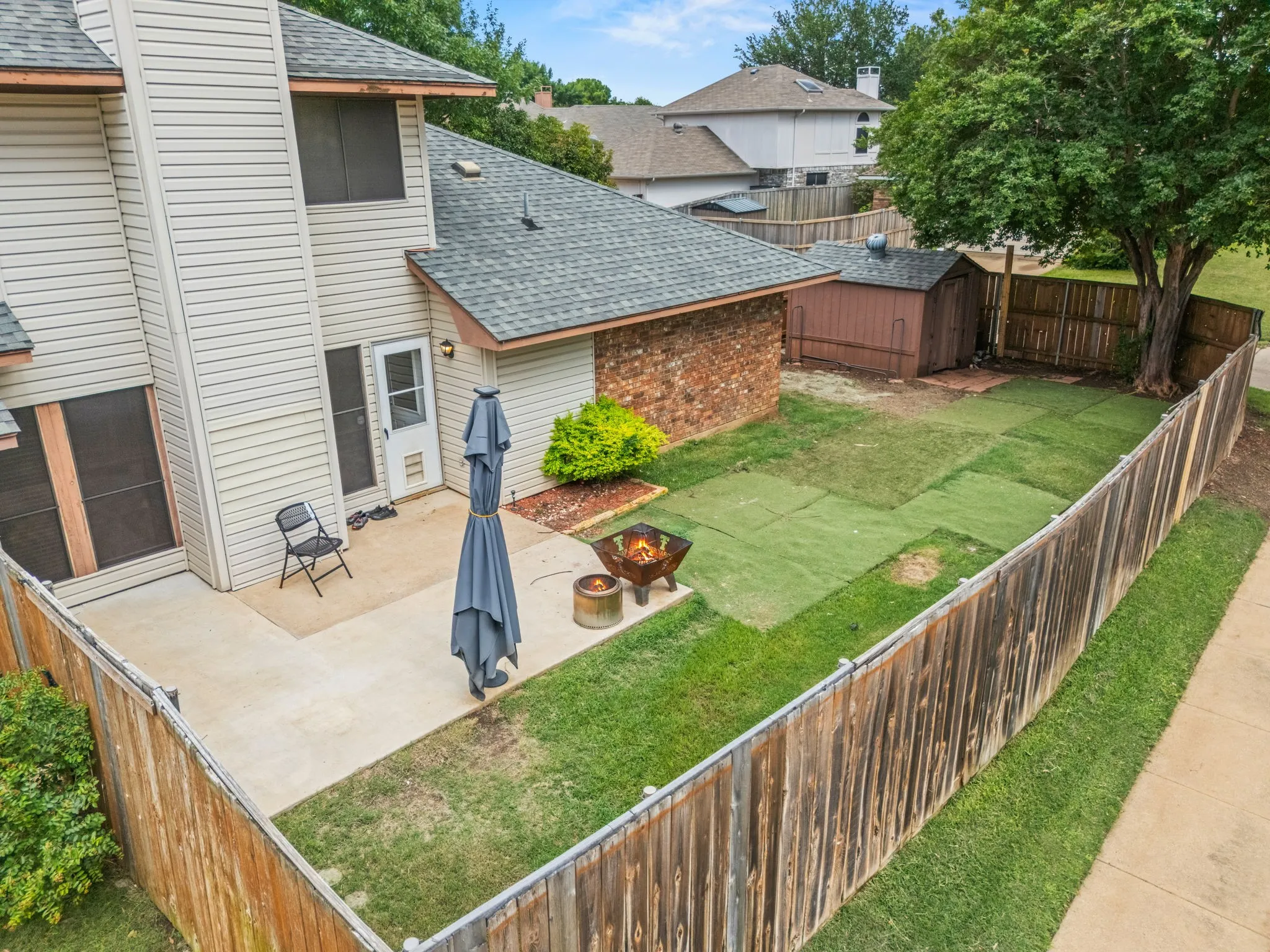 The backyard at 2060 Arbor Creek Drive #B, enclosed by a wood privacy fence, one of the most searched features in Carrollton, TX homes with a fenced backyard.