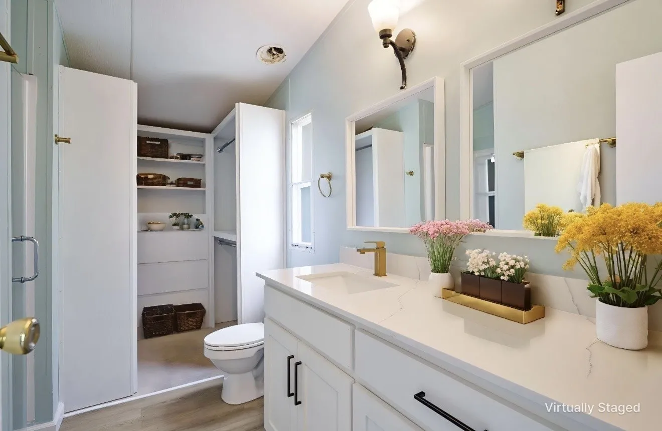 Bathroom featuring a double vanity with stone countertops, rectangular undermount sinks, and gold-finish faucets