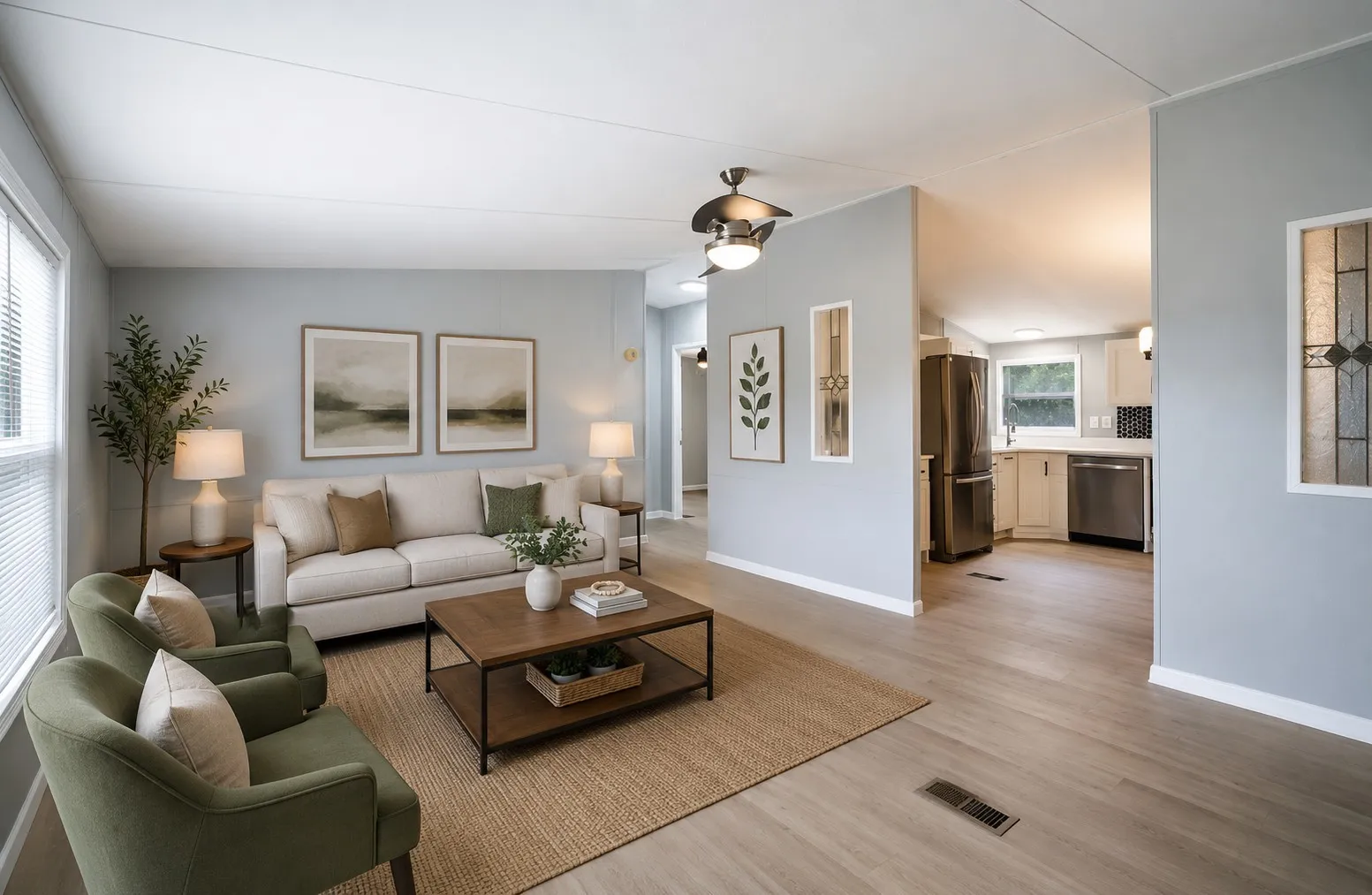 Bright living area featuring wood-finish flooring, light grey walls, and a ceiling fan