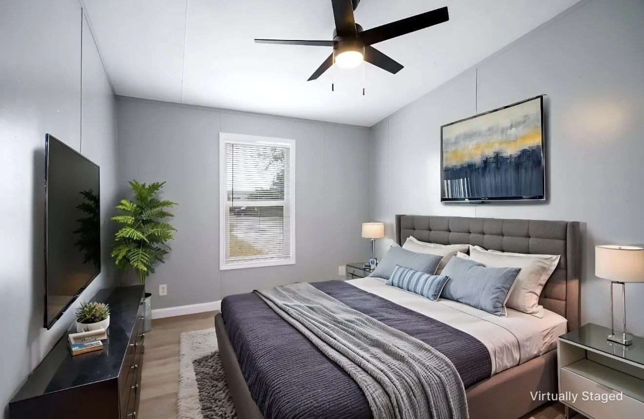 Bedroom featuring a ceiling fan, light gray wall paneling, and wood-finish flooring