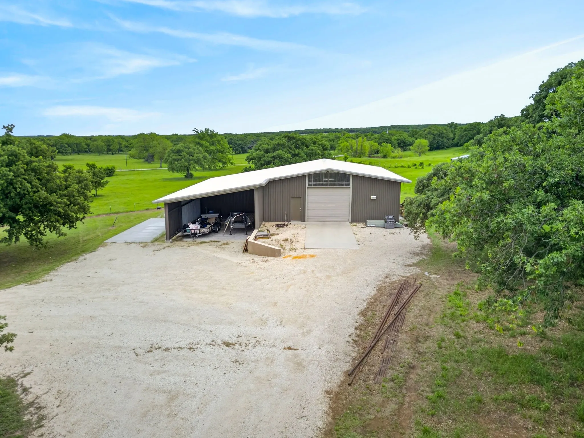 Metal outbuilding featuring a white sloped roof and an attached open-sided lean-to