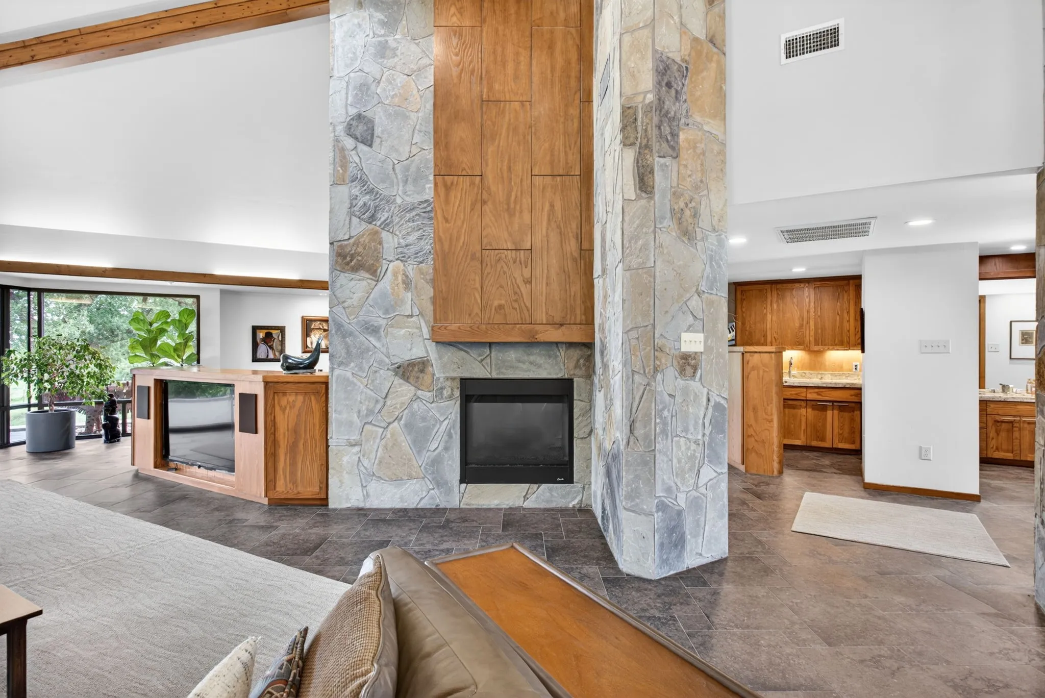 Stone-clad fireplace with a recessed firebox and wood-paneled mantel