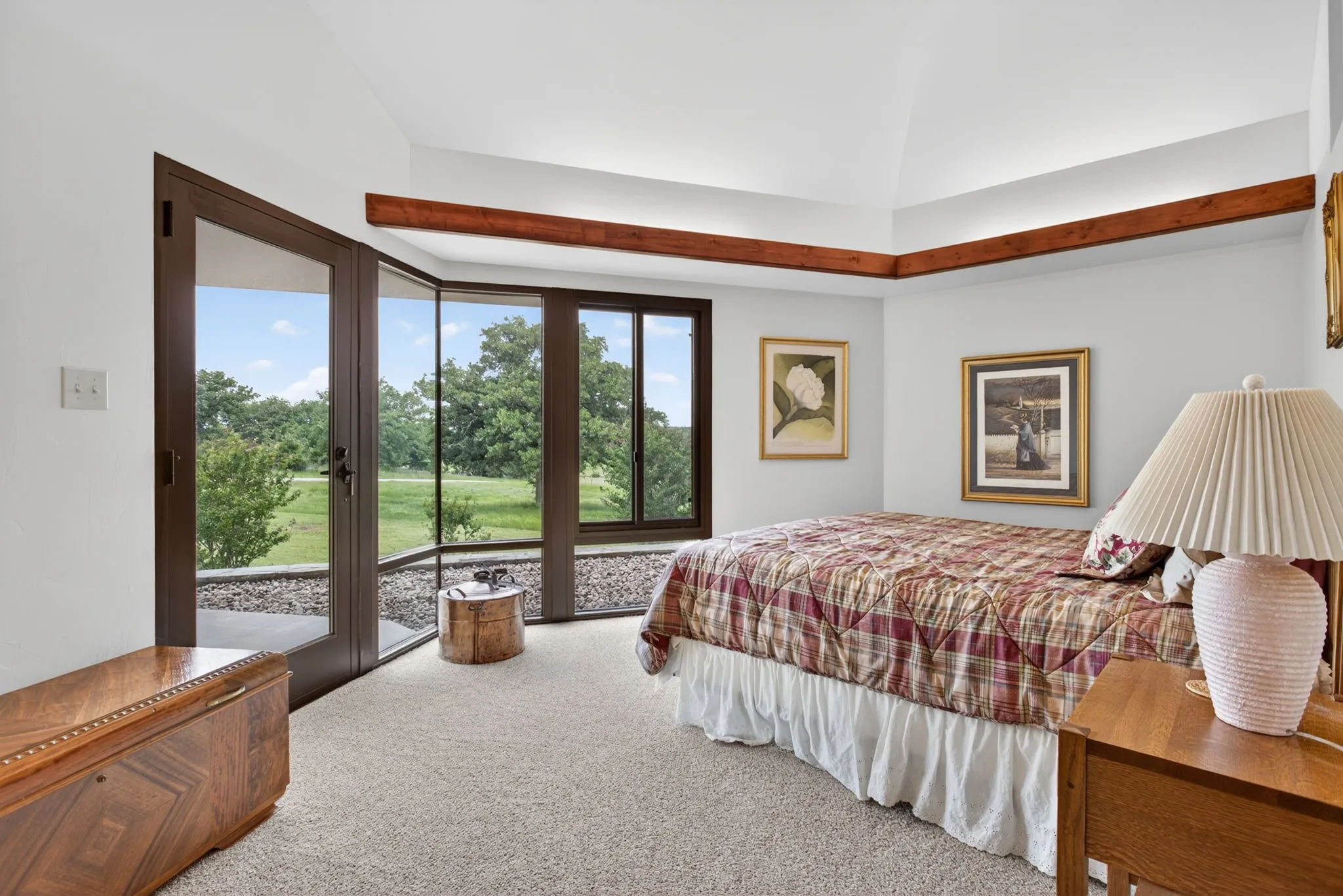 Room featuring a vaulted ceiling with exposed wood beams, expansive floor-to-ceiling windows, and direct patio​​‌​​​​‌​​‌‌​‌‌​​​‌‌​‌​‌​‌​​​‌​​ access