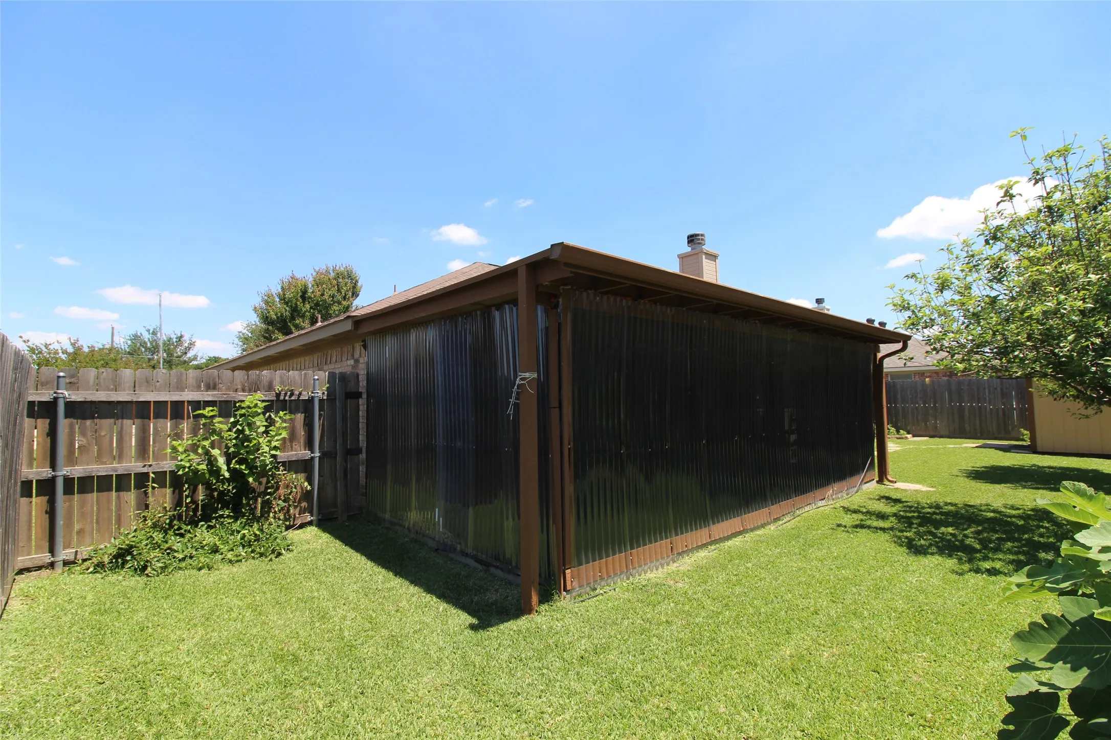 Backyard view of enclosed patio. The clear panels are removable and there are screens underneath that keep out mosquitos.