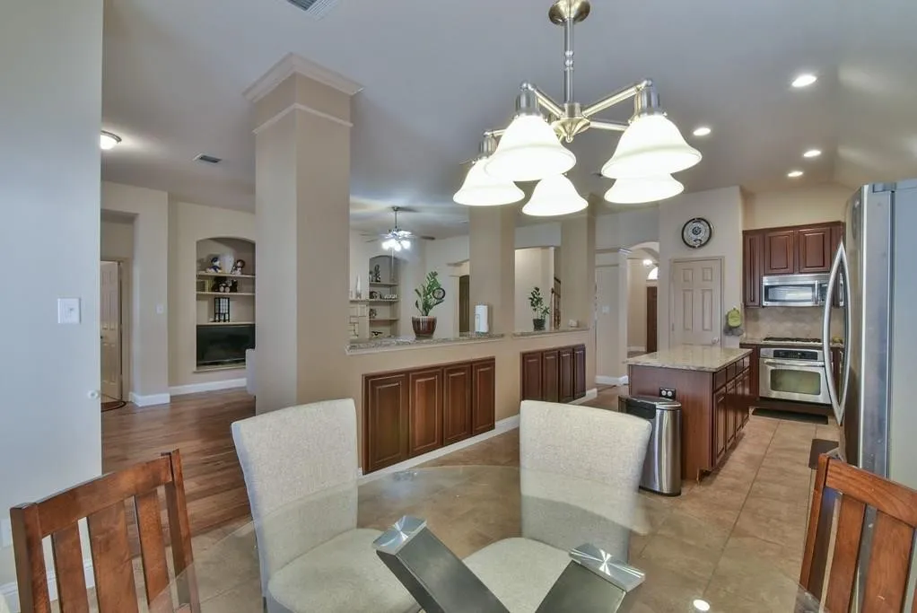 Spacious kitchen featuring dark wood cabinetry, stainless steel appliances, and a central island with granite countertop