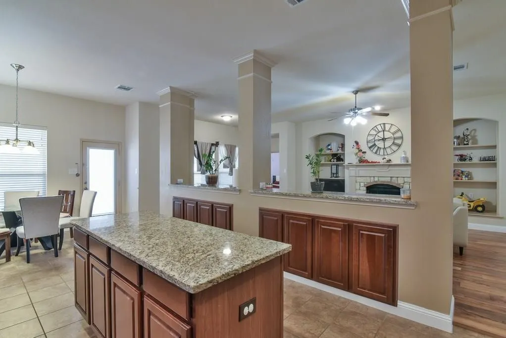 Kitchen island with granite countertop and rich wood-finish cabinetry