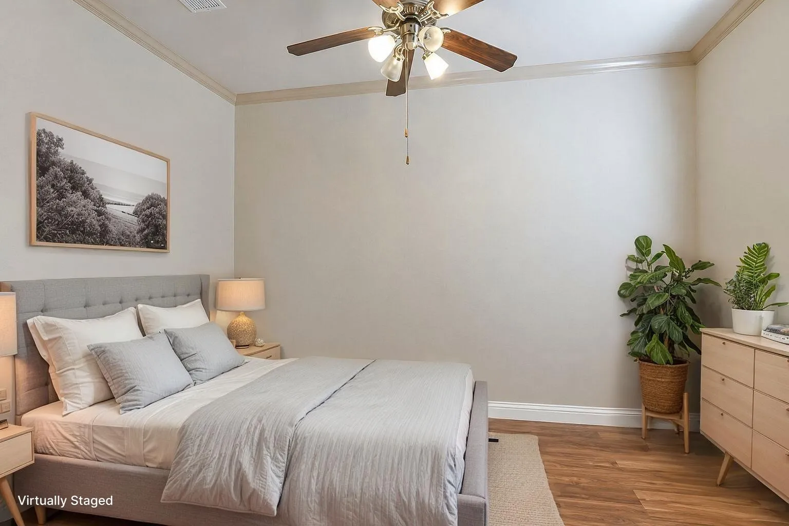 Spacious room featuring wood-finish flooring, crown molding, and a ceiling fan with integrated lighting