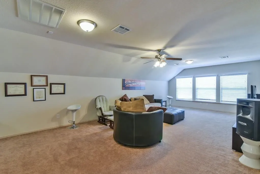Spacious bonus room featuring sloped ceilings, recessed lighting, a ceiling fan, and light brown carpeting
