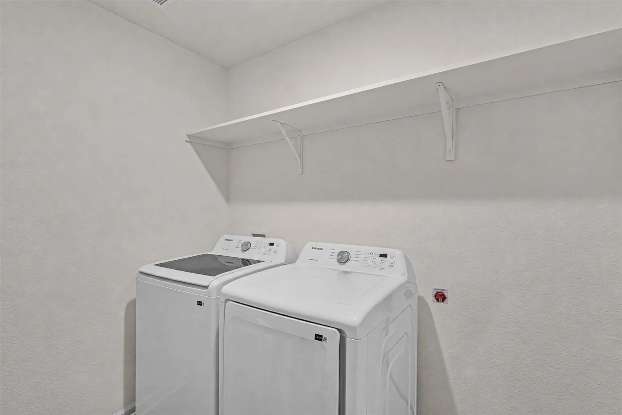 Dedicated laundry space featuring a built-in white shelf with supports