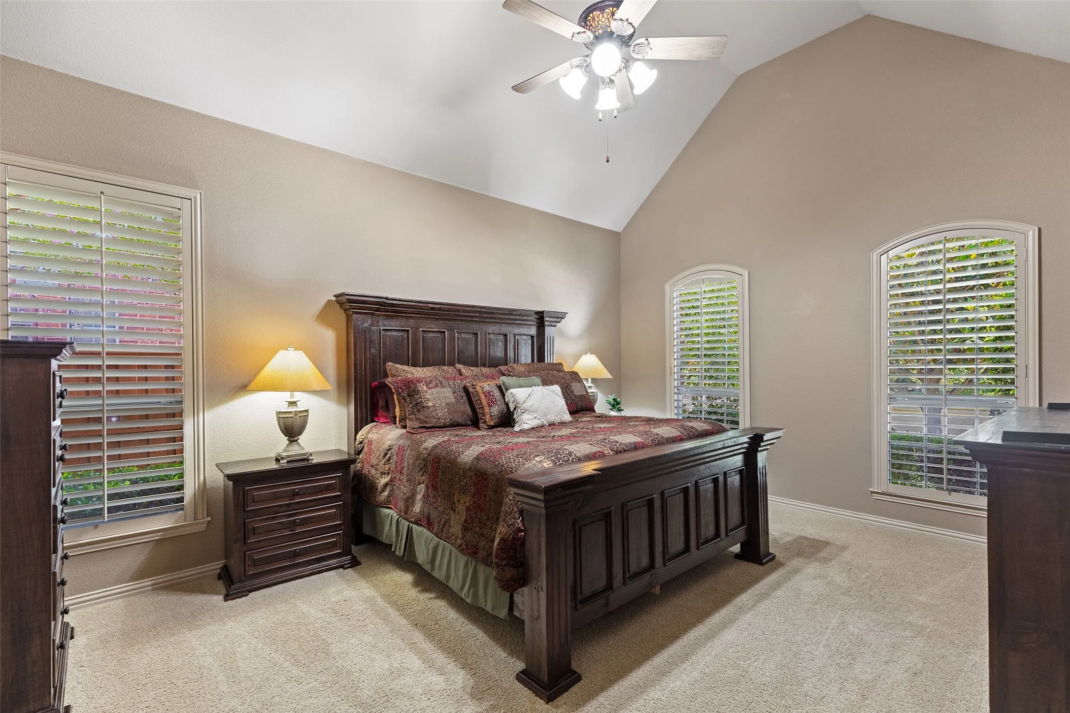 Escape to a spacious primary suite where vaulted ceilings and private bath access create a relaxing retreat.